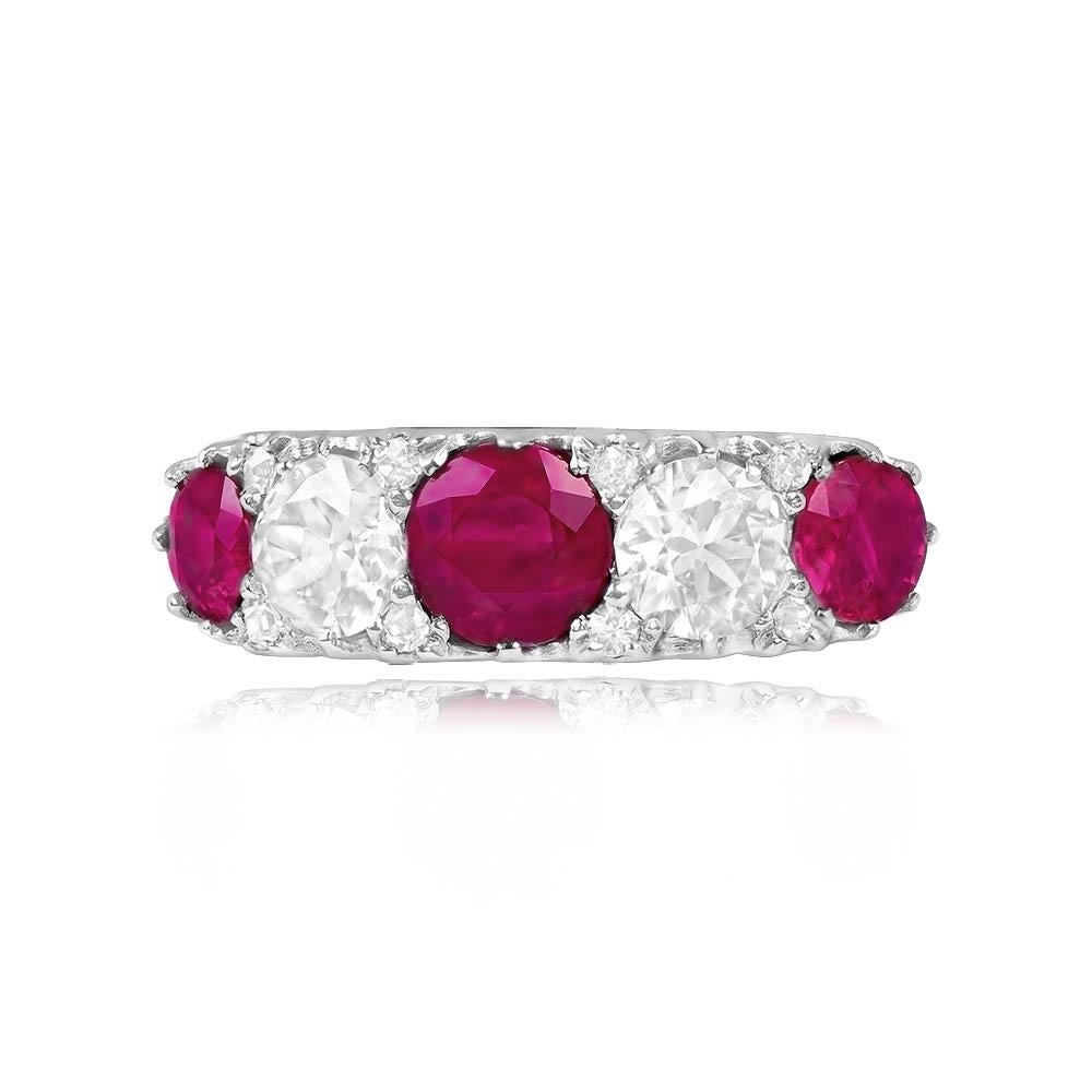 An enchanting antique ring adorned with three round-cut rubies, elegantly set in prongs, and complemented by two prong-set old European cut diamonds nestled in between. Four smaller single-cut diamonds on each side add a delicate touch, beautifully