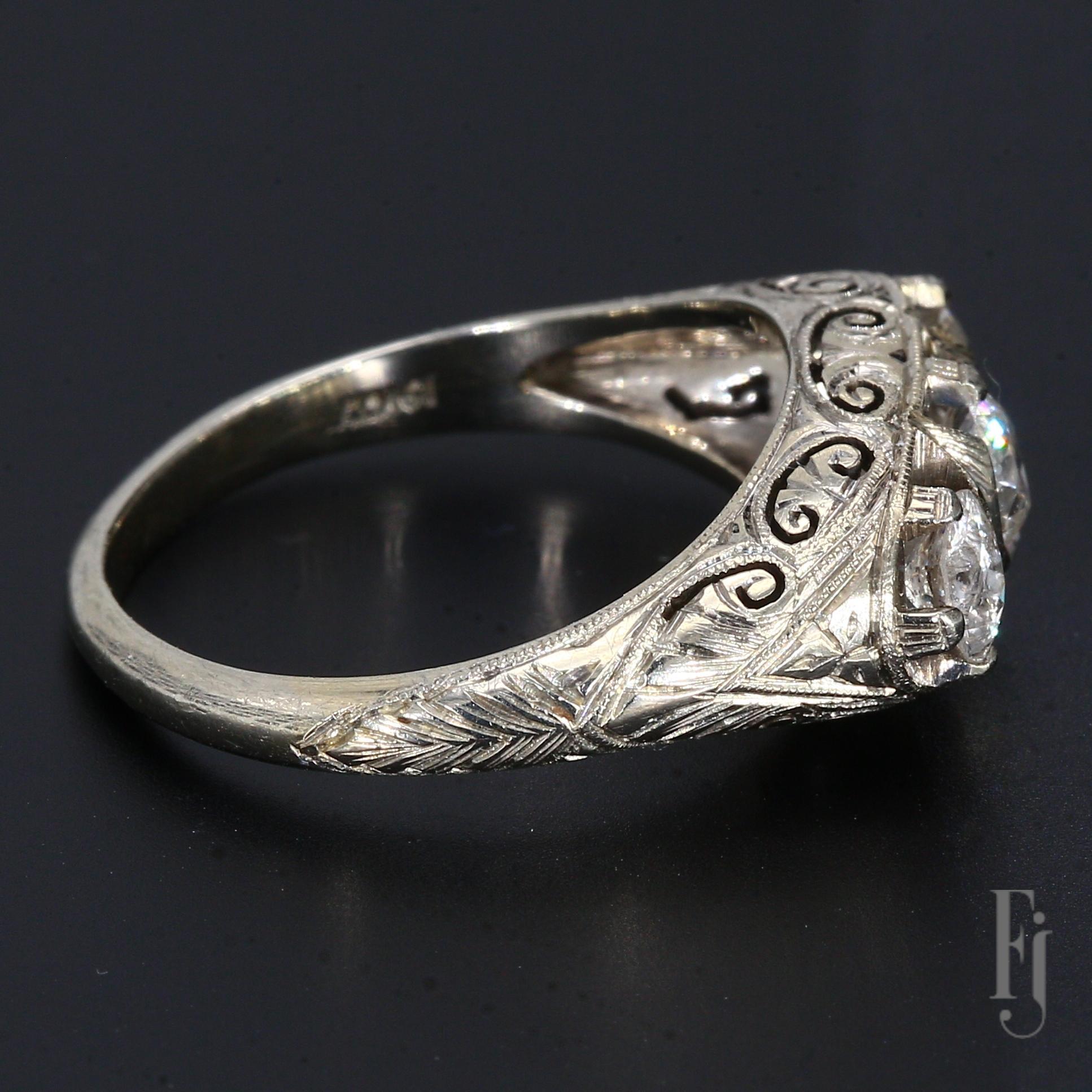 Voici une bague ancienne en or blanc 19k à design filigrane avec trois diamants, la pierre centrale pèse ~0,50cts et les deux pierres d'accentuation pèsent ~0,40cts chacune.

Taille - 7.25
Poids total - 4,72 g
A3