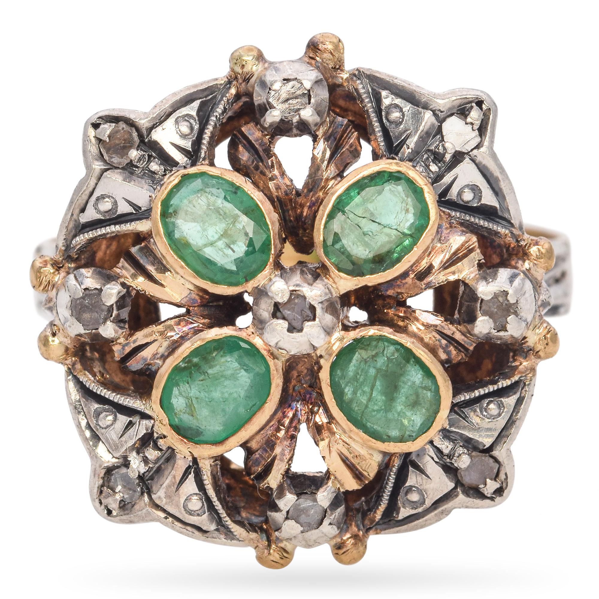 Antique 19K Gold and Silver Emerald and Diamond Ring. This exquisite ring is crafted in 19k gold and silver top. The ring features five vibrant green emeralds set in a floral pattern, surrounded by rose-cut diamonds. The intricate design showcases