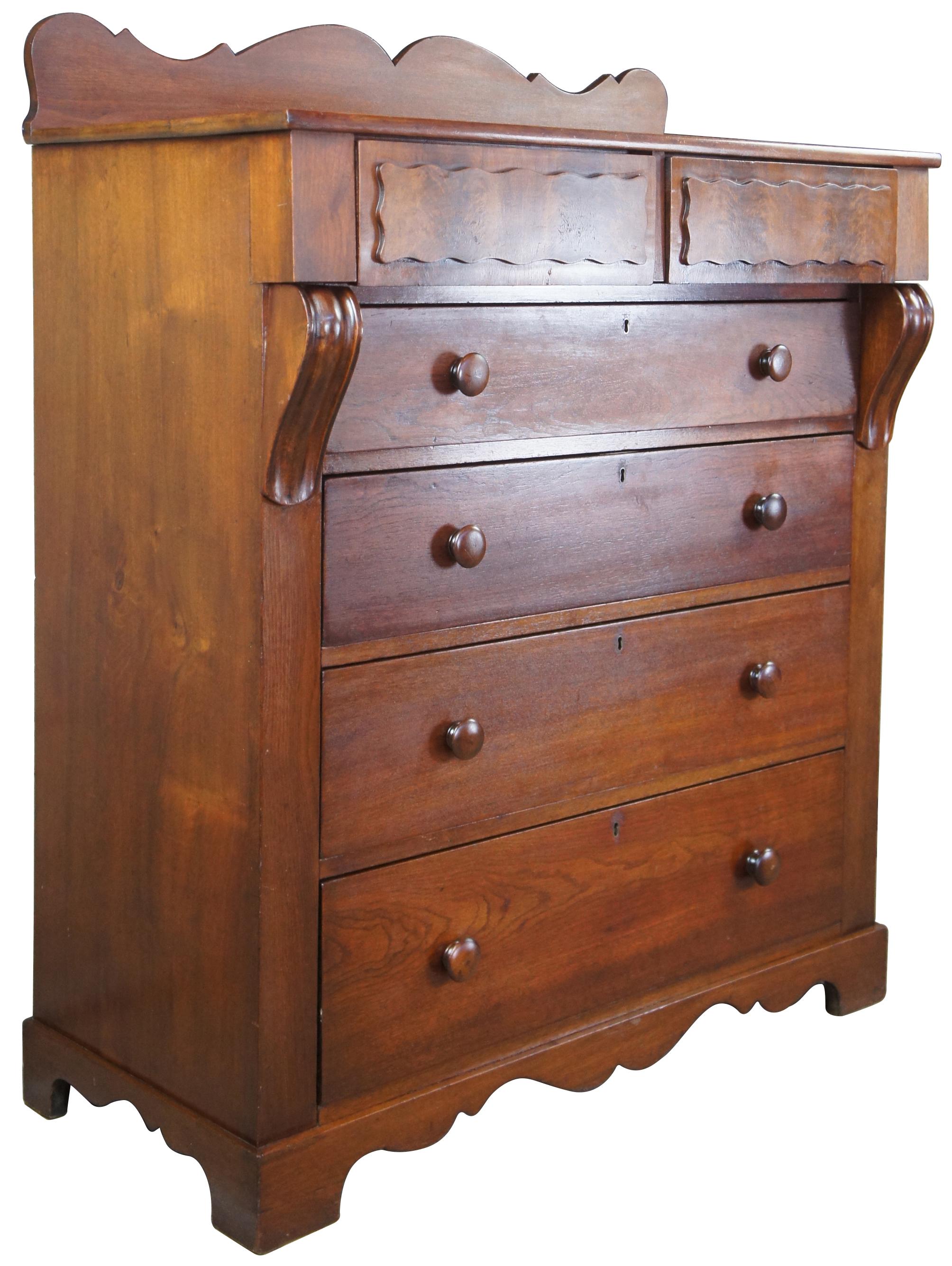 Antique 19th century American Empire tallboy dresser or gentleman's chest. Made of mahogany with serpentine backsplash, raised flame mahogany upper drawer panels supported by corbel embellishments over four drawers. 

Surface height - 47