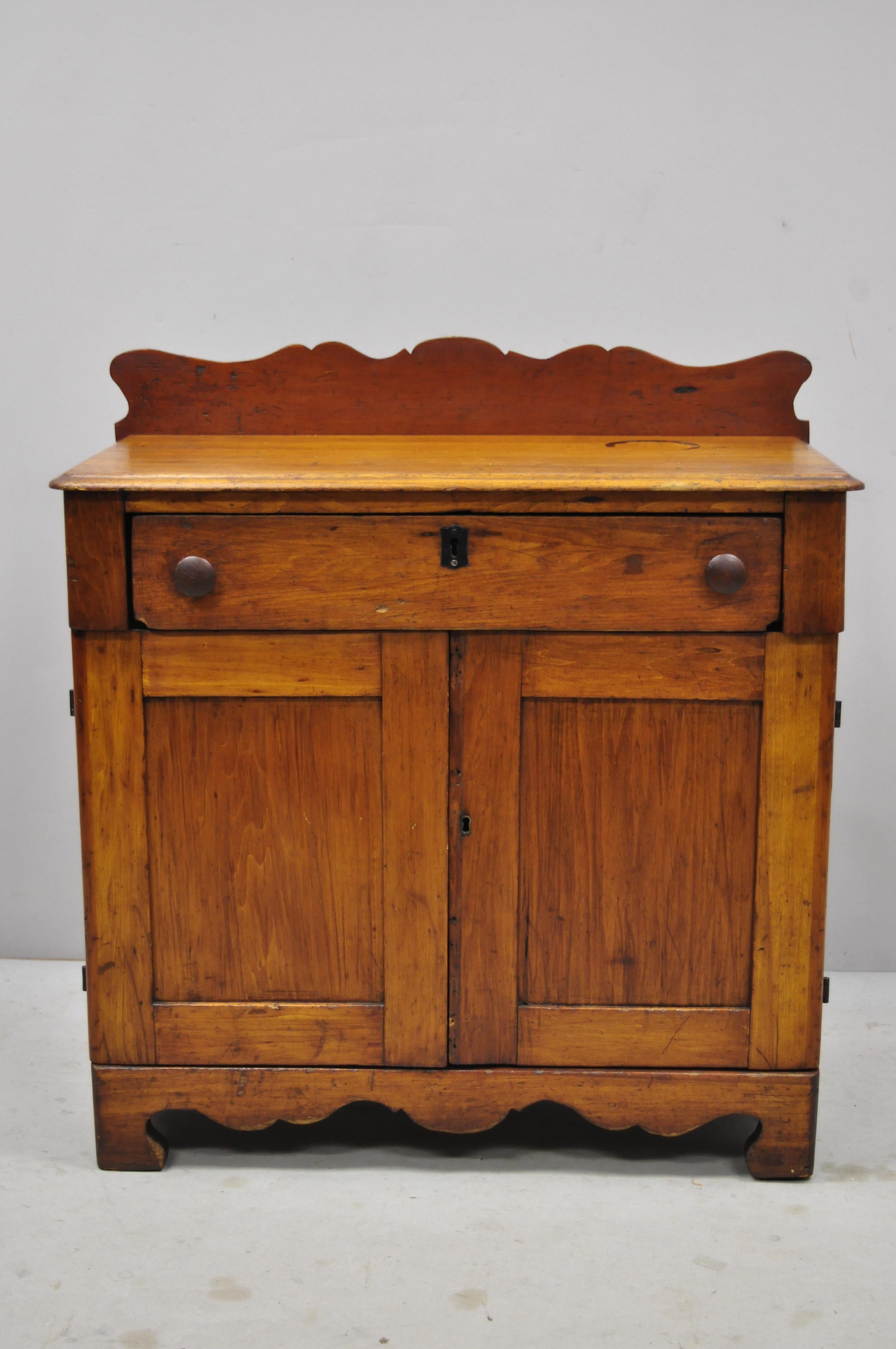 Antique 19th century American primitive chestnut Washstand nightstand work table. Listing includes a blue painted interior, carved backsplash, solid wood construction, beautiful wood grain, 2 swing doors, 1 drawer, very nice antique item, circa