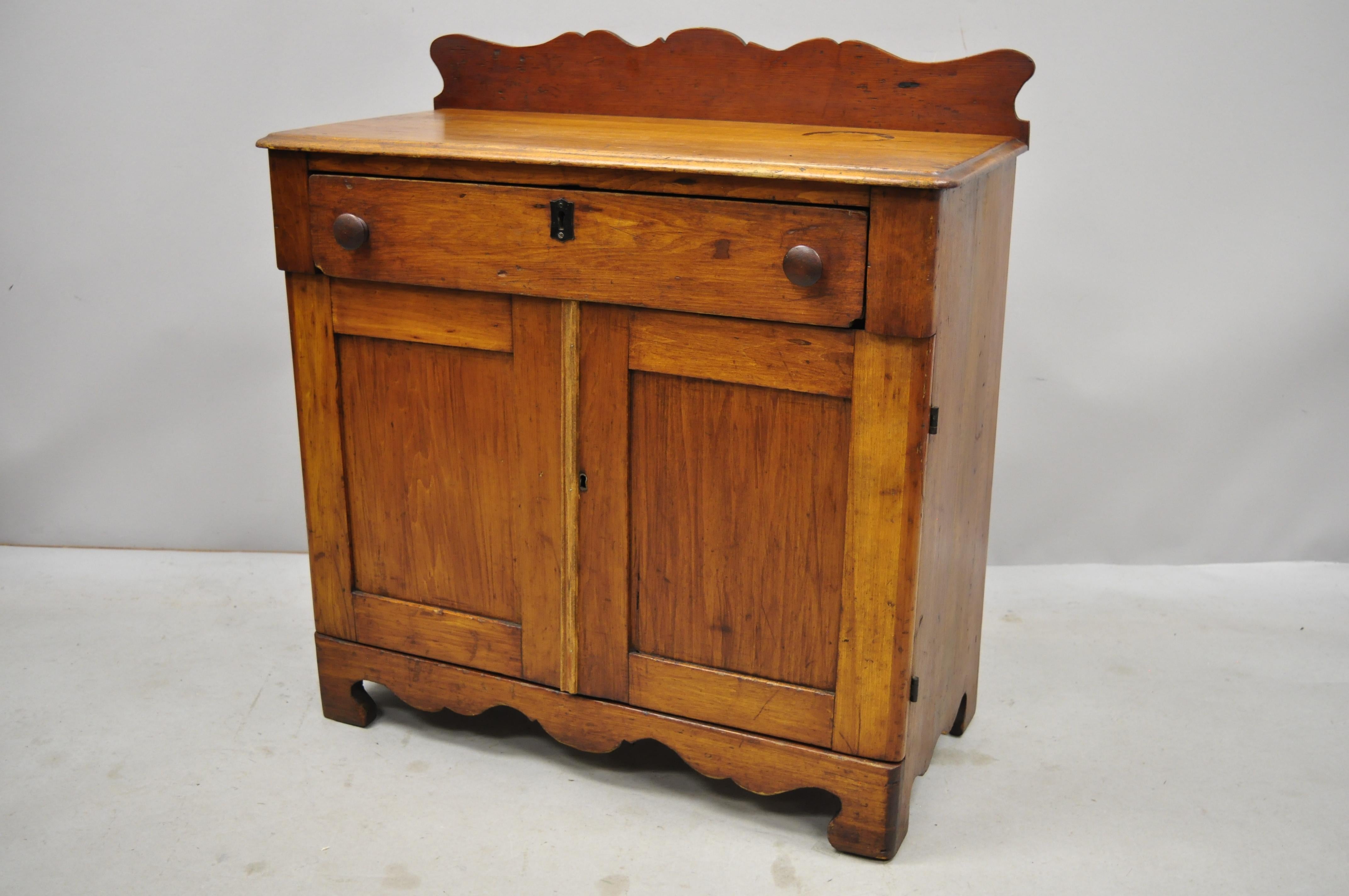 Antique 19th century American Primitive chestnut washstand nightstand work table. Item features blue painted interior, carved backsplash, solid wood construction, beautiful wood grain, 2 swing doors, 1 drawer, very nice antique item, circa mid-19th
