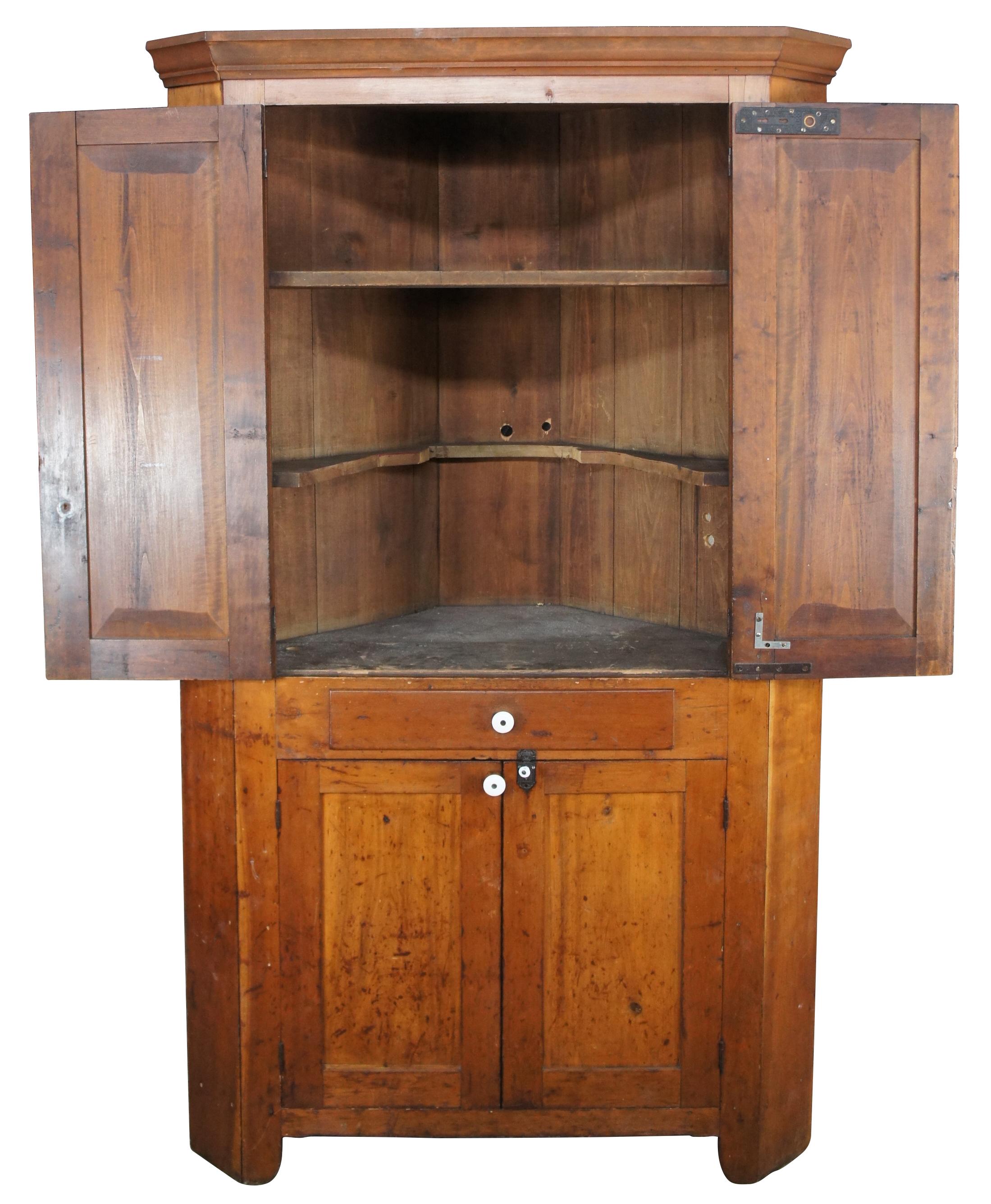 Rustic American corner cupboard, circa 1870s. Made from maple and constructed using hand cut nails. Features a warm patina with distressing from age. Hardware is iron and porcelain. 

Measures: 24