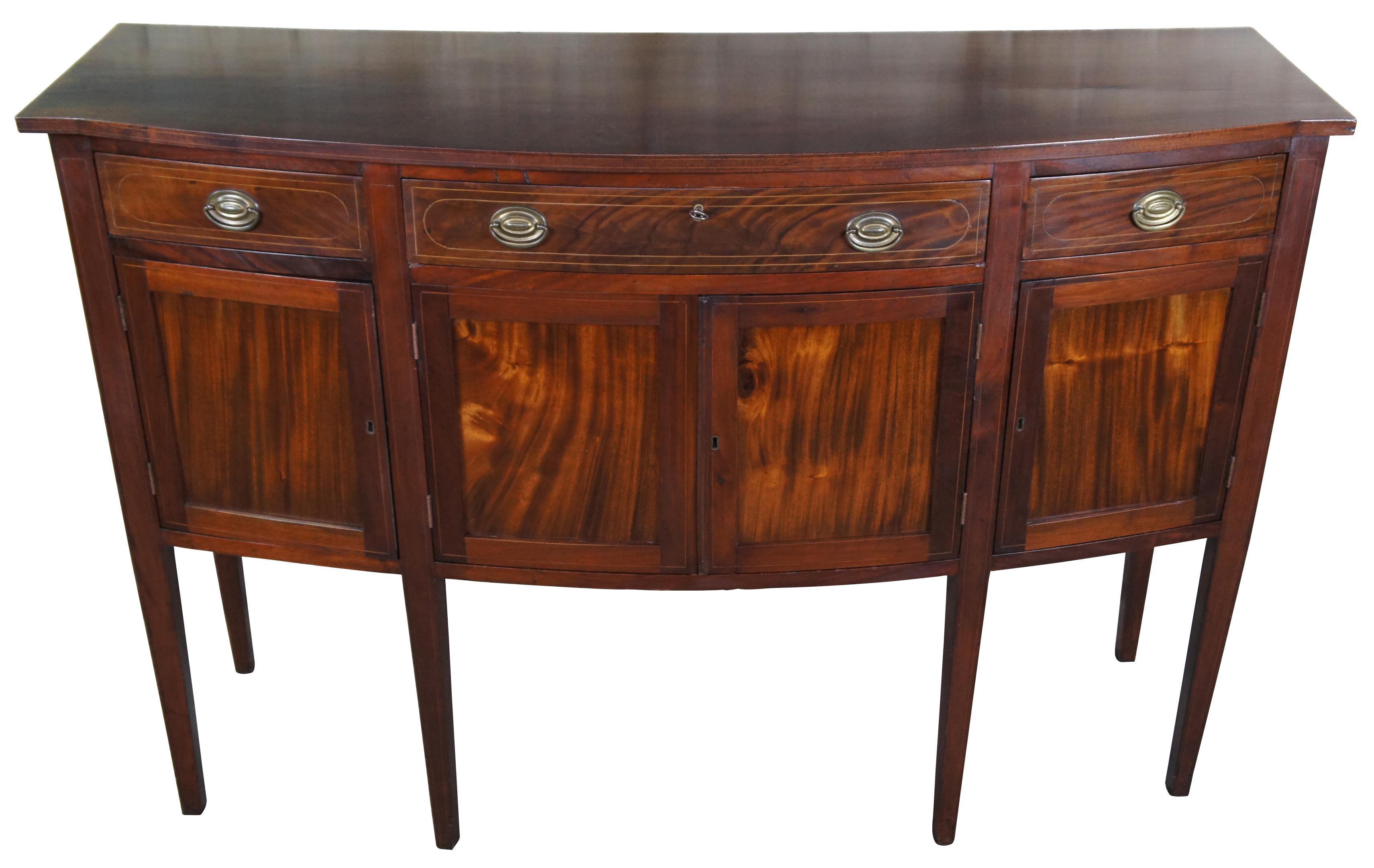 Antique American Sheraton buffet, circa first half 19th century. Made of mahogany featuring a bow front of three drawers and lower cabinets with shelf. Includes yew inlay and brass hardware. The cabinet is supported by long square tapered legs.