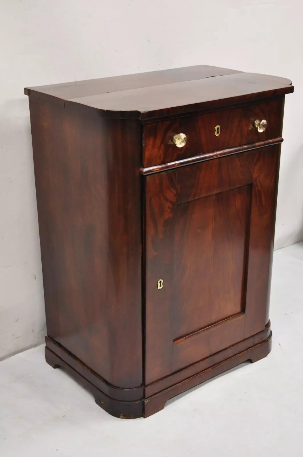 Antico gabinetto a un'anta in mogano Sheraton Crotch del XIX secolo. L'articolo presenta un cassetto a coda di rondine con tiretti in vetro, un'anta singola a battente, una bella impiallacciatura in mogano crotch, un mobile antico molto bello. Circa