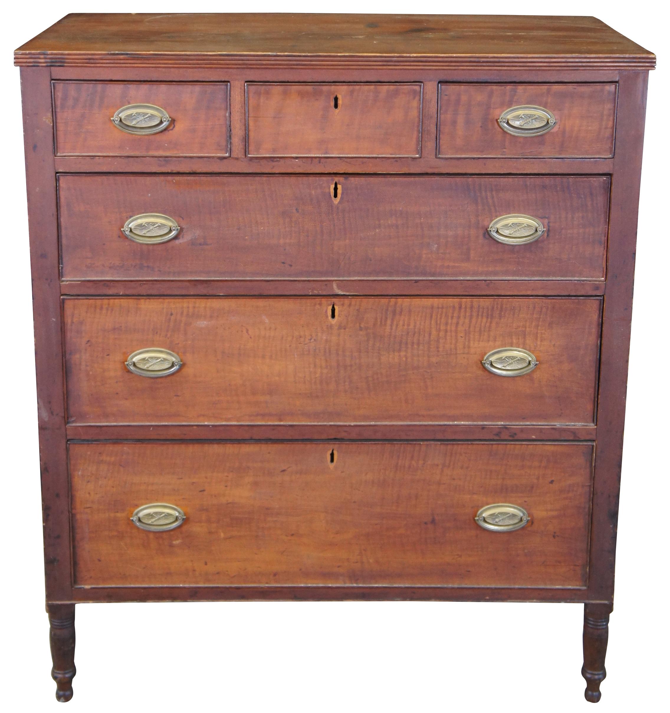 An impressive American Sheraton / Federal tallboy chest of drawers, circa first quarter 19th century. Made of flamed birch featuring four drawers with Neoclassical / Hepplewhite oval crossed cannon bail hardware with the phrase Trafalgar Copenhagen.