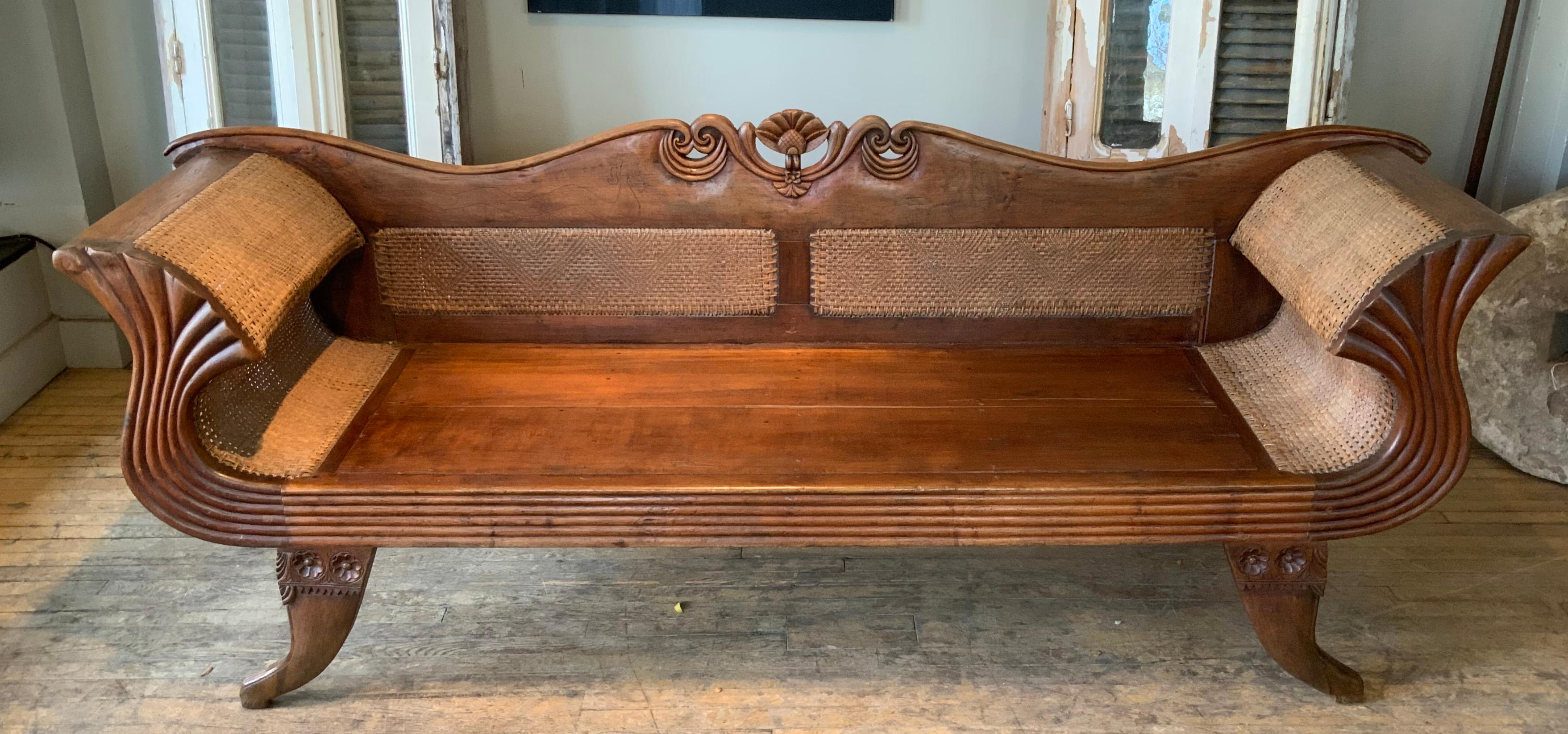 An extraordinary antique Anglo Caribbean teak and cane settee, with beautiful scrolled and curved arms, and a carved arched back. wonderful scale and details!