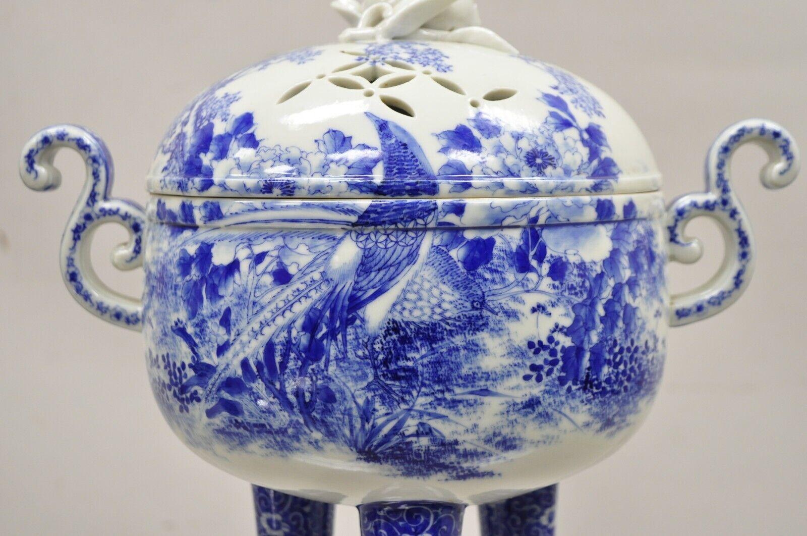 Ancien brûleur d'encens sur pied en porcelaine chinoise bleue et blanche du 19ème siècle. L'objet présente des scènes bleues et blanches avec des oiseaux et des arbres, des poignées à volutes, une base tripode à pieds, un couvercle percé, une très