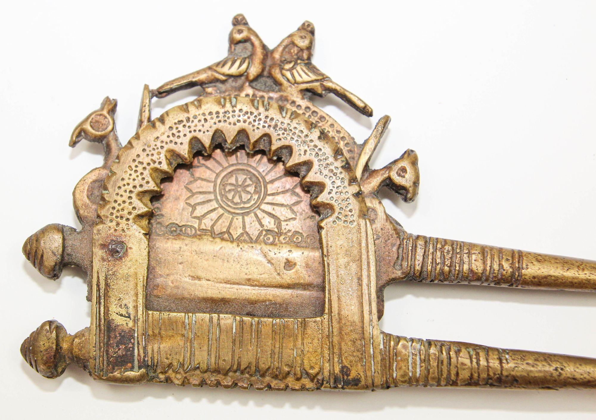A late 19th or early 20th century Indian brass betel nut cutter from the North Western regions. 
This is a betel-nut cutter made of brass using casting technique with bird motifs and rosette.
It has a steel blade grafted into the body for strength
