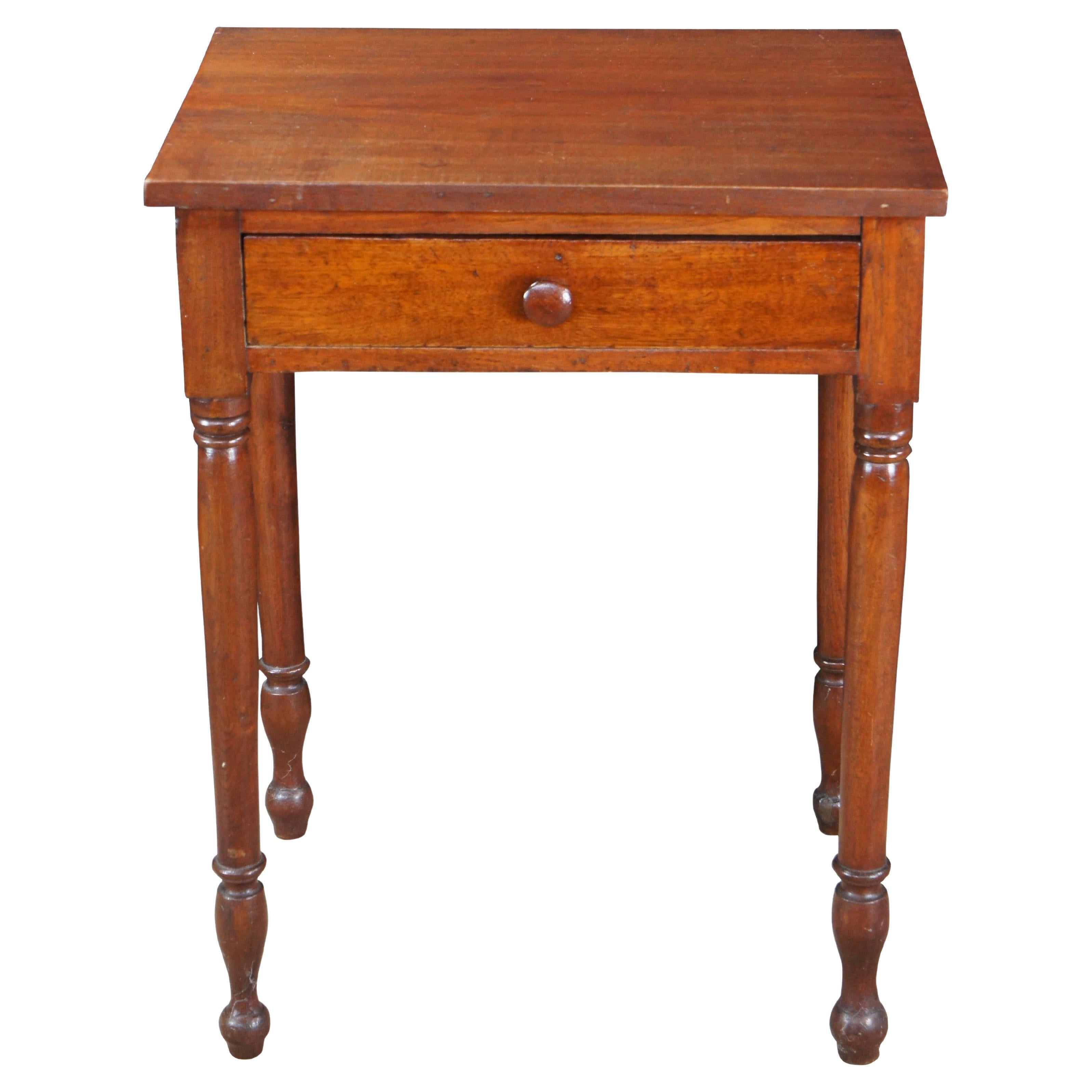 Preciosa mesa auxiliar antigua de nogal americano de mediados del siglo XIX. Presenta una forma rectangular con cajón de cola de milano a mano con pomo de madera torneada. La mesa se apoya en cuatro esbeltas patas torneadas y acanaladas que
