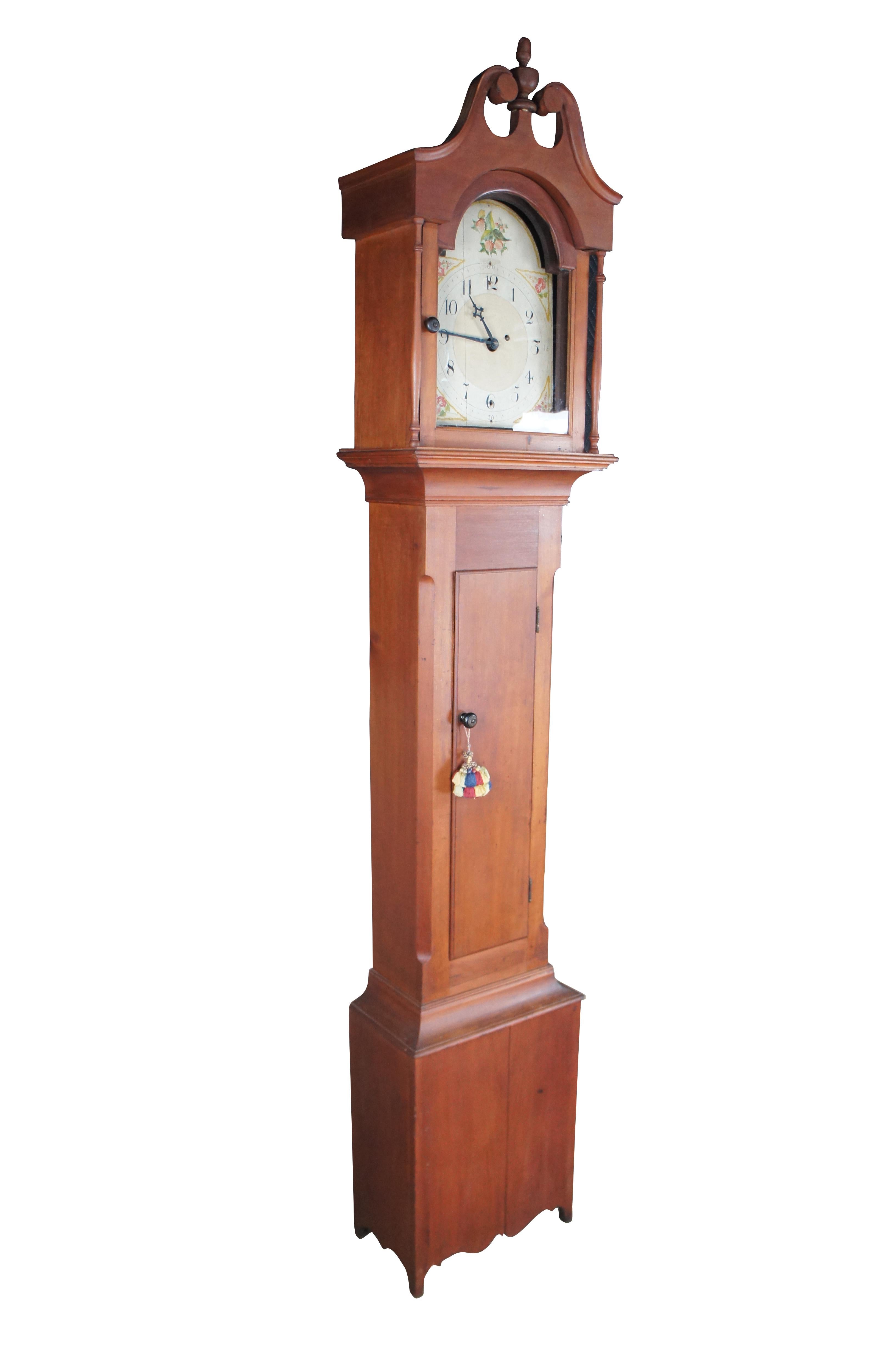 A beautiful Seth Thomas long case clock, circa first half 19th century. Features an American poplar case in Early American styling with an open pediment, columns around a glass face, chamfered center and scrolled lower apron. The hand painted face
