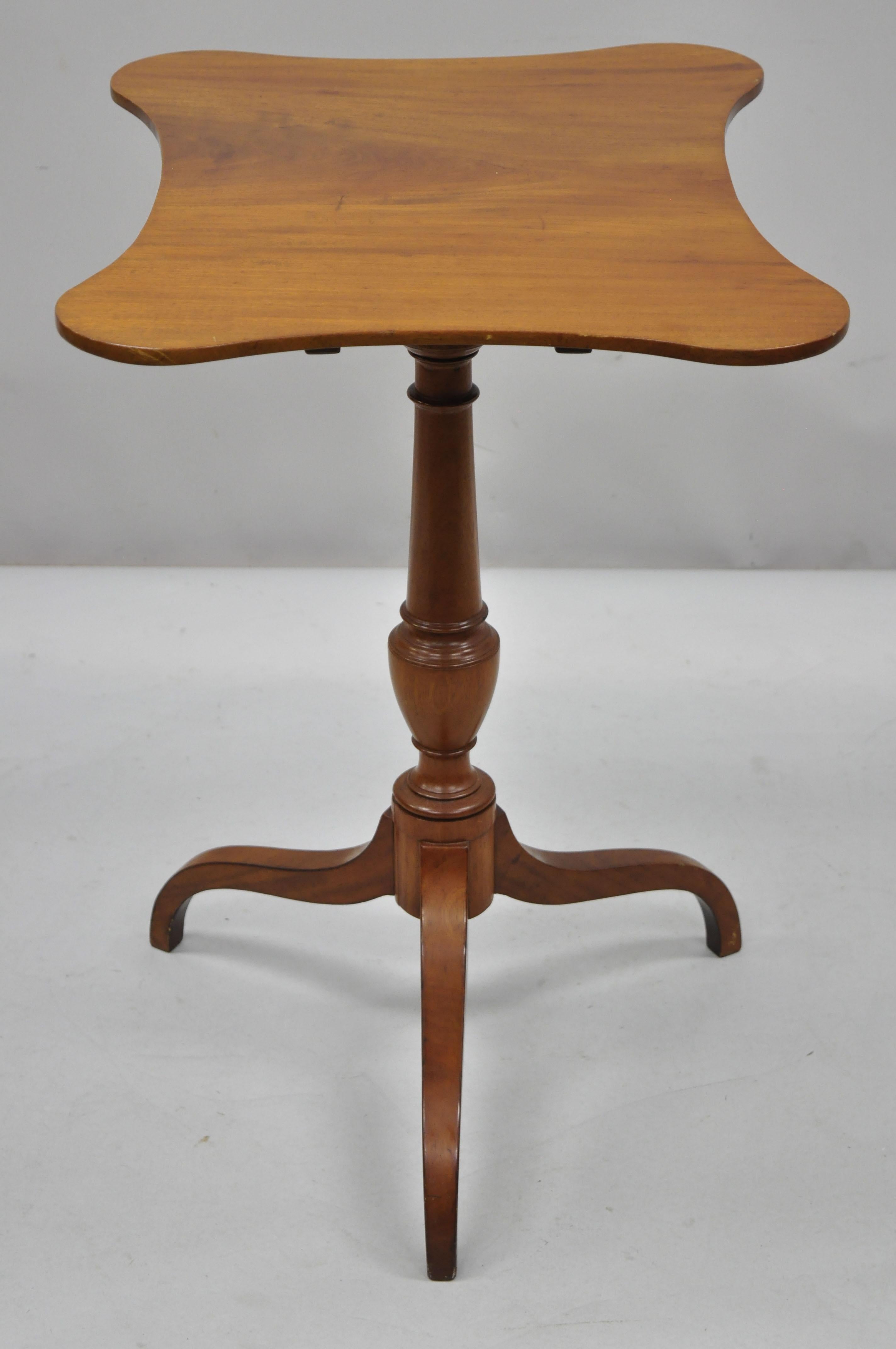 Antique 19th century English Sheraton mahogany tilt-top tea table with shaped edge top. Item features a tripod pedestal base, shapely top with beveled underside edge, solid wood construction, beautiful wood grain Measurements: Down 28