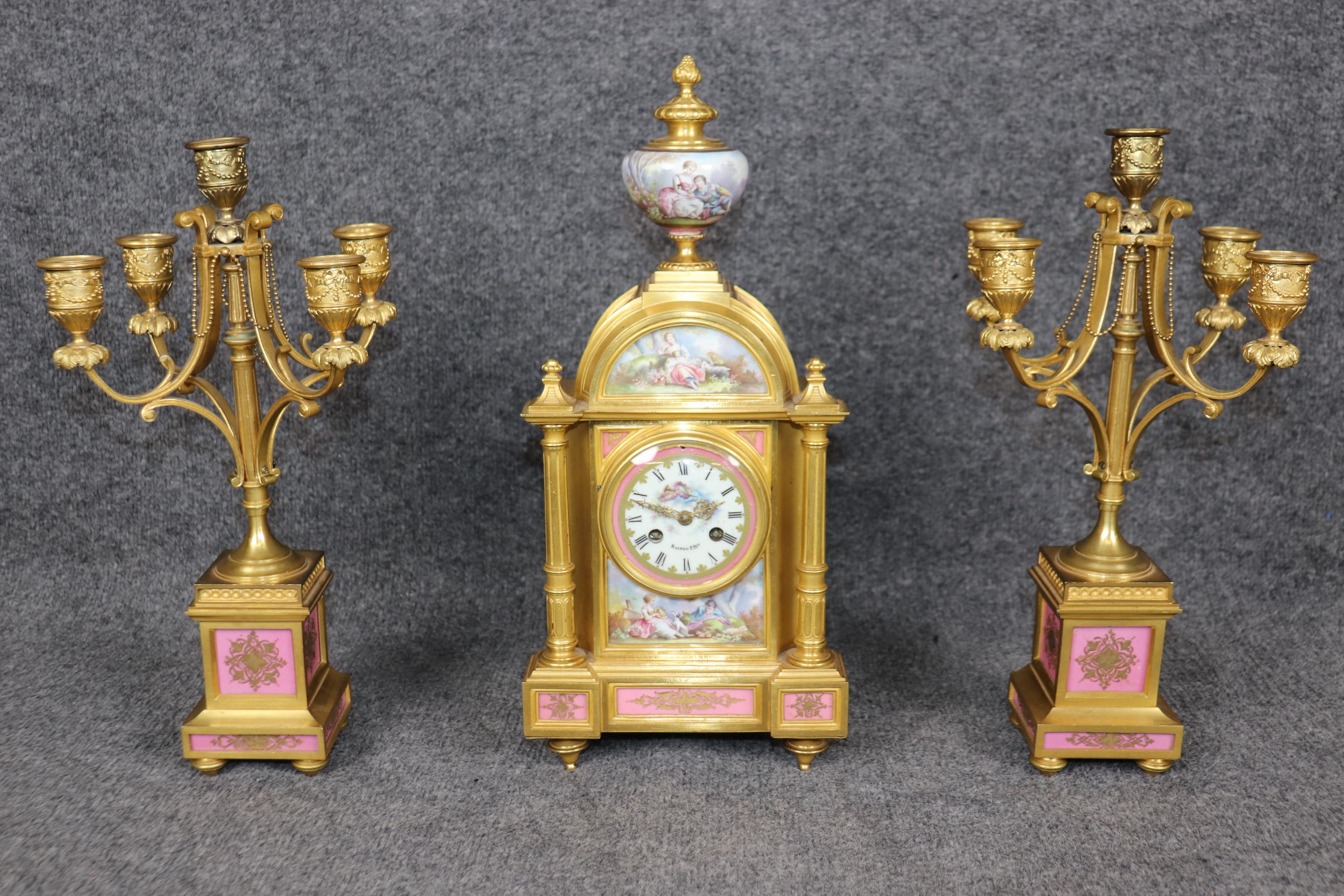 Dimensions (Clock) - H: 16 1/2 in W: 7 1/2 in D: 4 1/4 in 
Dimensions (Candelabras) - H: 14 3/4 in W: 8 1/2 in D: 8 1/2 in 

This exquisite 19th-century clock set, crafted by the renowned French clockmaker Raingo Frères, showcases the elegance and