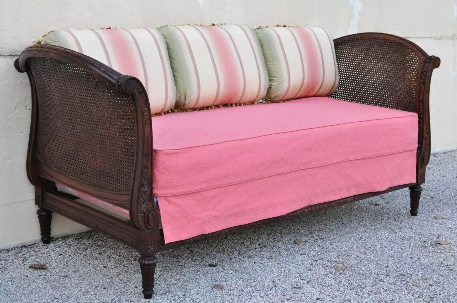 Sofá-cama francés Luis XVI del s. XIX, tallado en nogal y caña. El artículo incluye paneles de doble caña, colchón a medida, soporte a medida e impresionantes almohadas de doble cara tapizadas en seda de color rosa, dorado y verde de 12