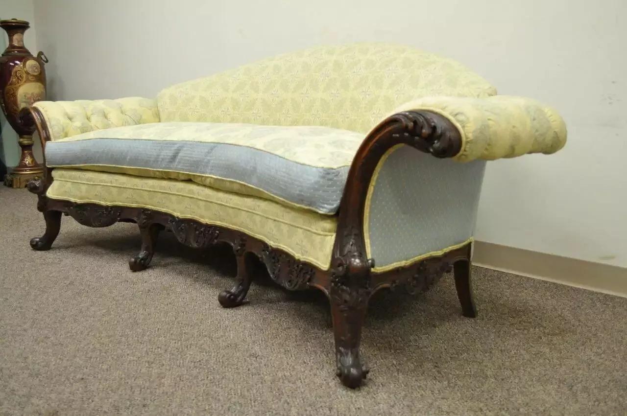 Antico divano a bracci arrotolati in stile georgiano con telaio curvo in mogano intagliato del XIX secolo. L'articolo è caratterizzato da una struttura dalle curve stravaganti, da braccioli decorati e arrotolati, da sei gambe, da un cuscino in piuma