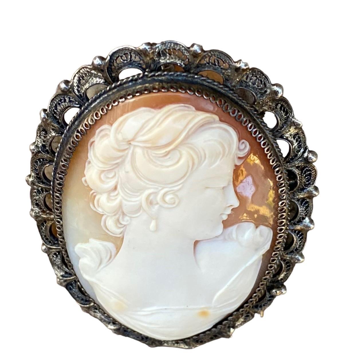 An antique late 19th c. Italian beautifully detailed and hand carved shell cameo brooch/pendant mounted in a .800 silver filigree setting. Carved in deep relief with fine details.   
