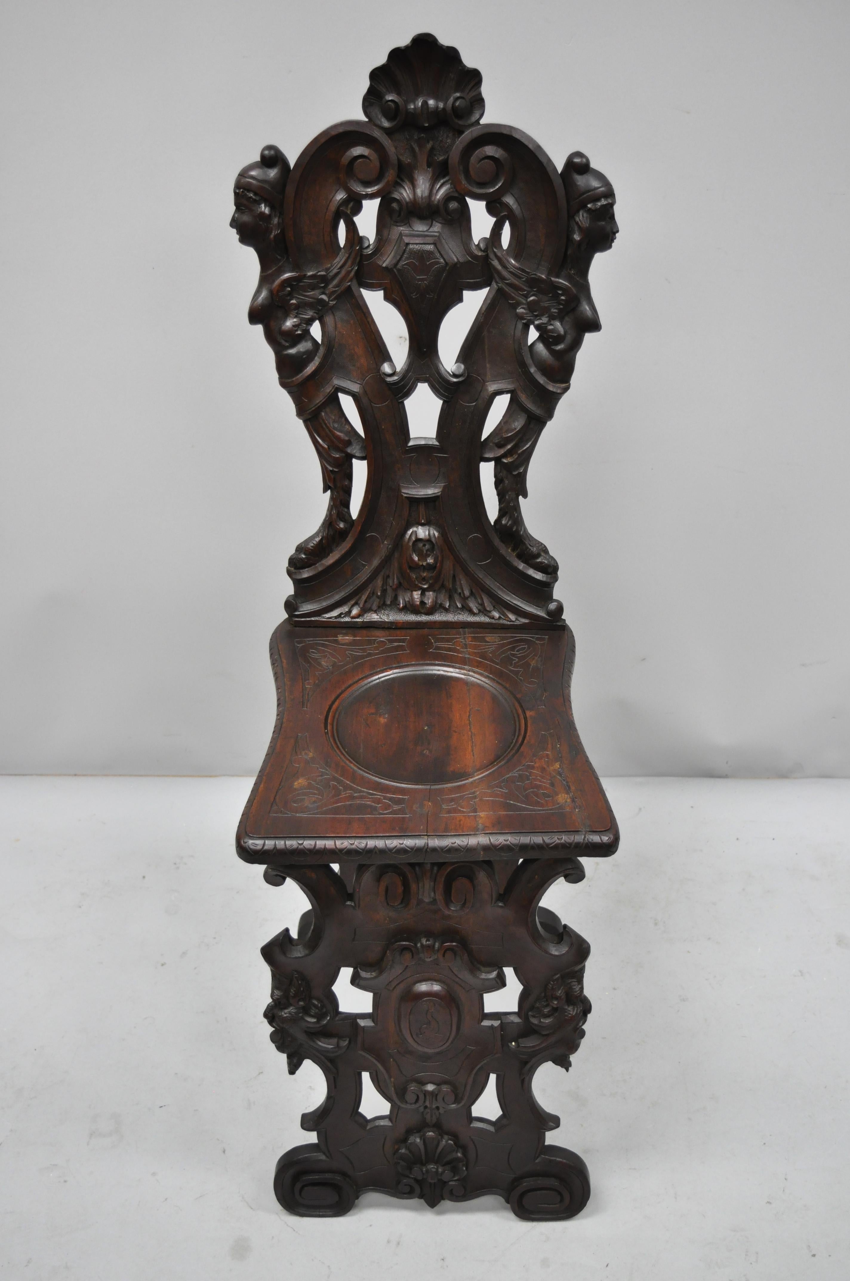 Antique 19th century Italian carved walnut figural Sgabello chair with winged maidens. Item features satyr faces to base, full carved winged maidens to back, other leafy carvings and scrollwork, solid wood construction, finely carved details, very