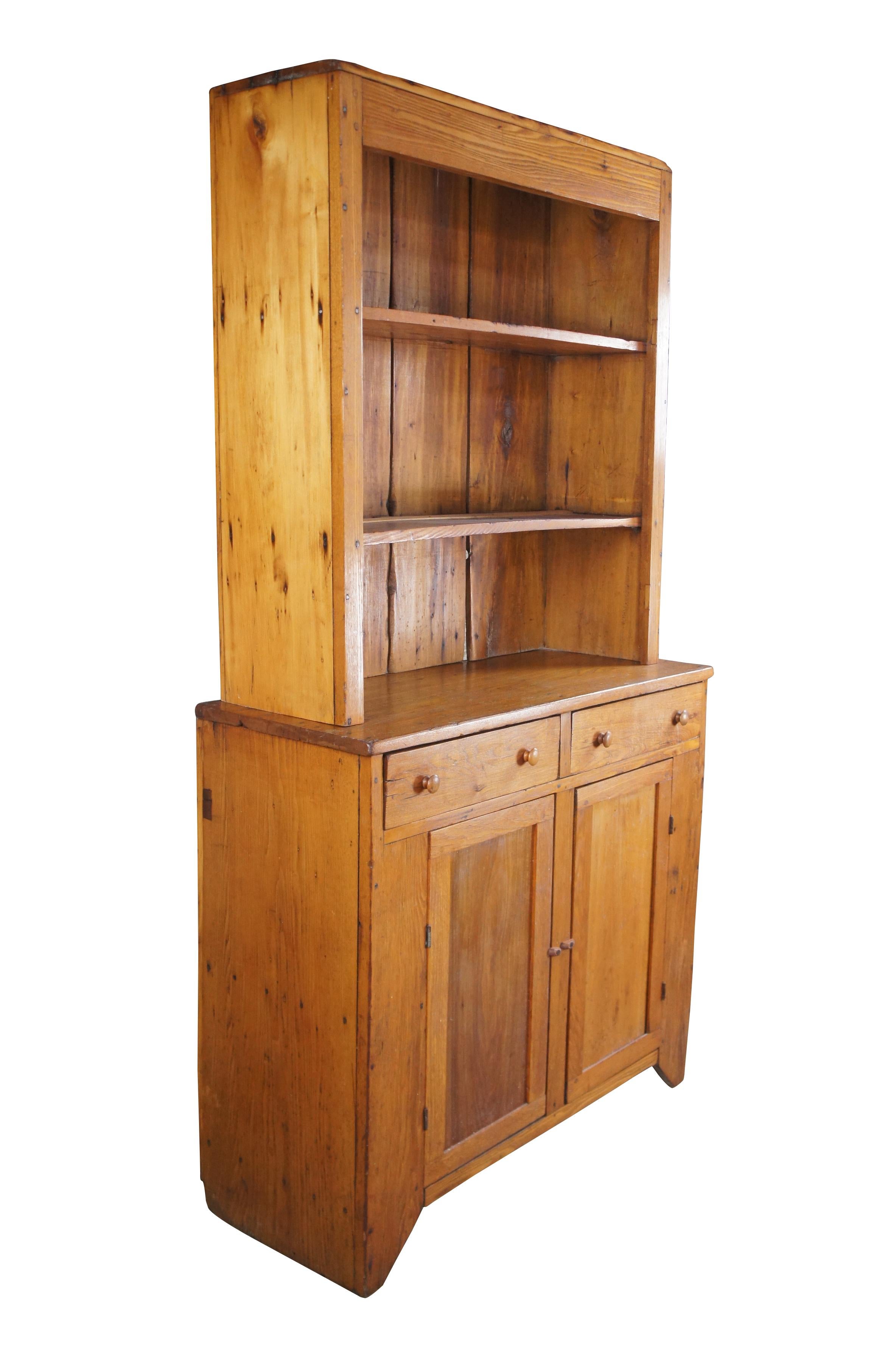 Early 19th century American Primitive pewter hutch or china cupboard. 2 piece design made from oak with two shelves along the top. The base has two hand dovetailed drawers over a lower two door latched cabinet with shelf. Made using handcut nails
