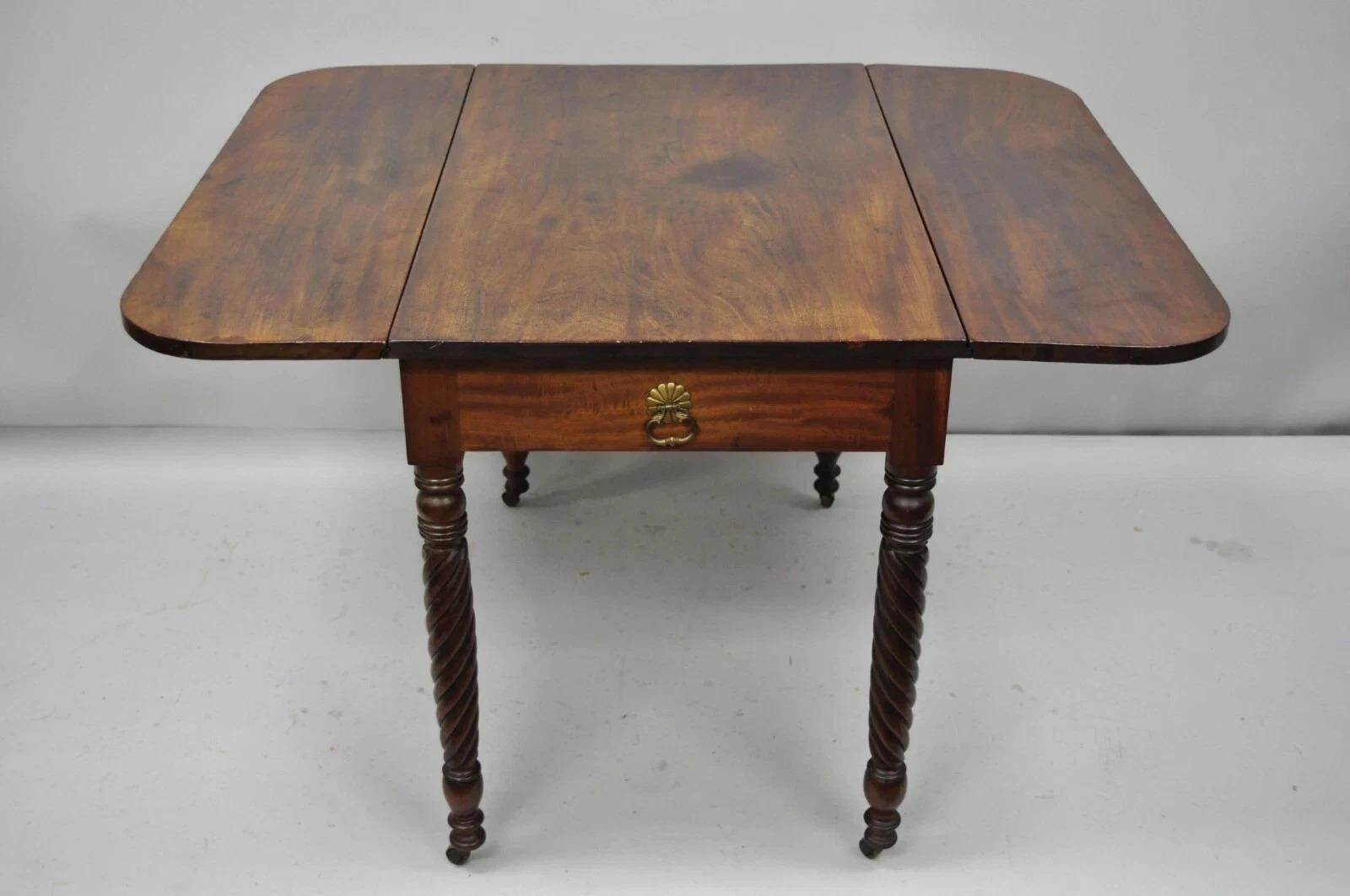 Antique 19th C. Sheraton Mahogany Turn Carved Spiral Leg Drop Leaf Dining Table. Item features solid crotch mahogany, 2 false drawers, turn carved spiral legs, 2 brass drop pulls, rolling casters, remarkable aged patina, quality American