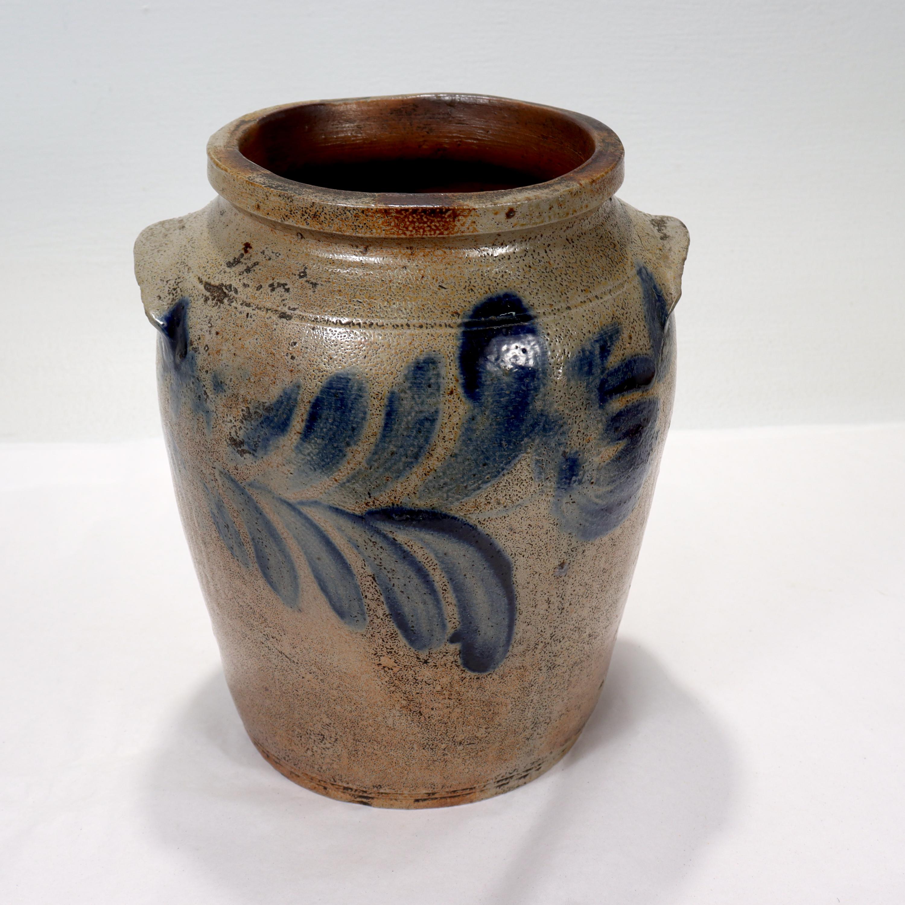 A fine antique blue decorated salt glaze stoneware crock.

With slightly tapered sides, twin handles, and blue underglaze stylized tulip decoration to both sides. 

Found in Maryland (possibly originating in Baltimore) and measuring