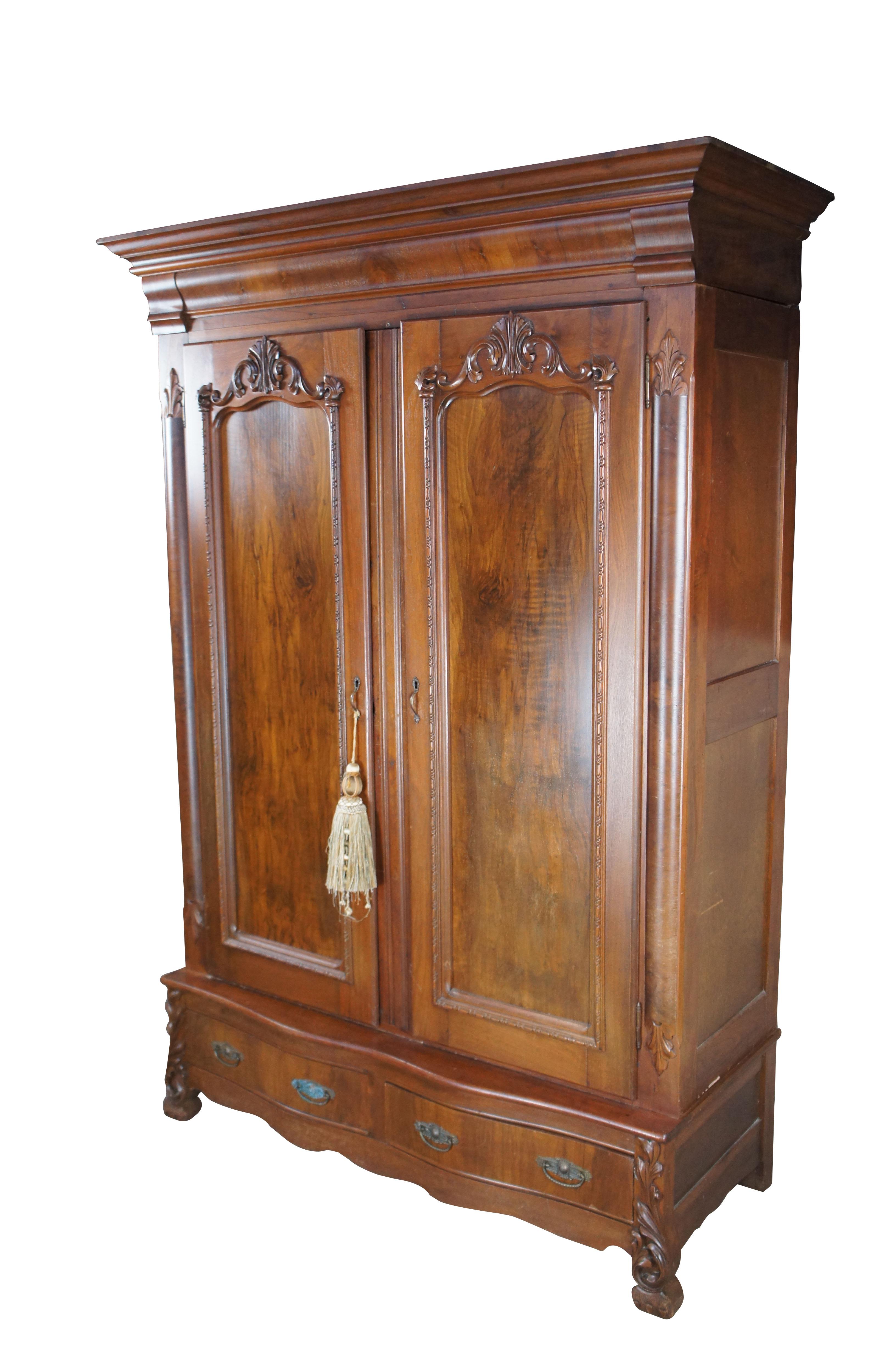 Impressive late 19th Century Victorian Knockdown Armoire. Made from walnut with ornately carved front featuring crotch walnut doors over a serpentine oxbow base with two drawers.  The wardrobe opens to two shelves which could be removed in lieu of a