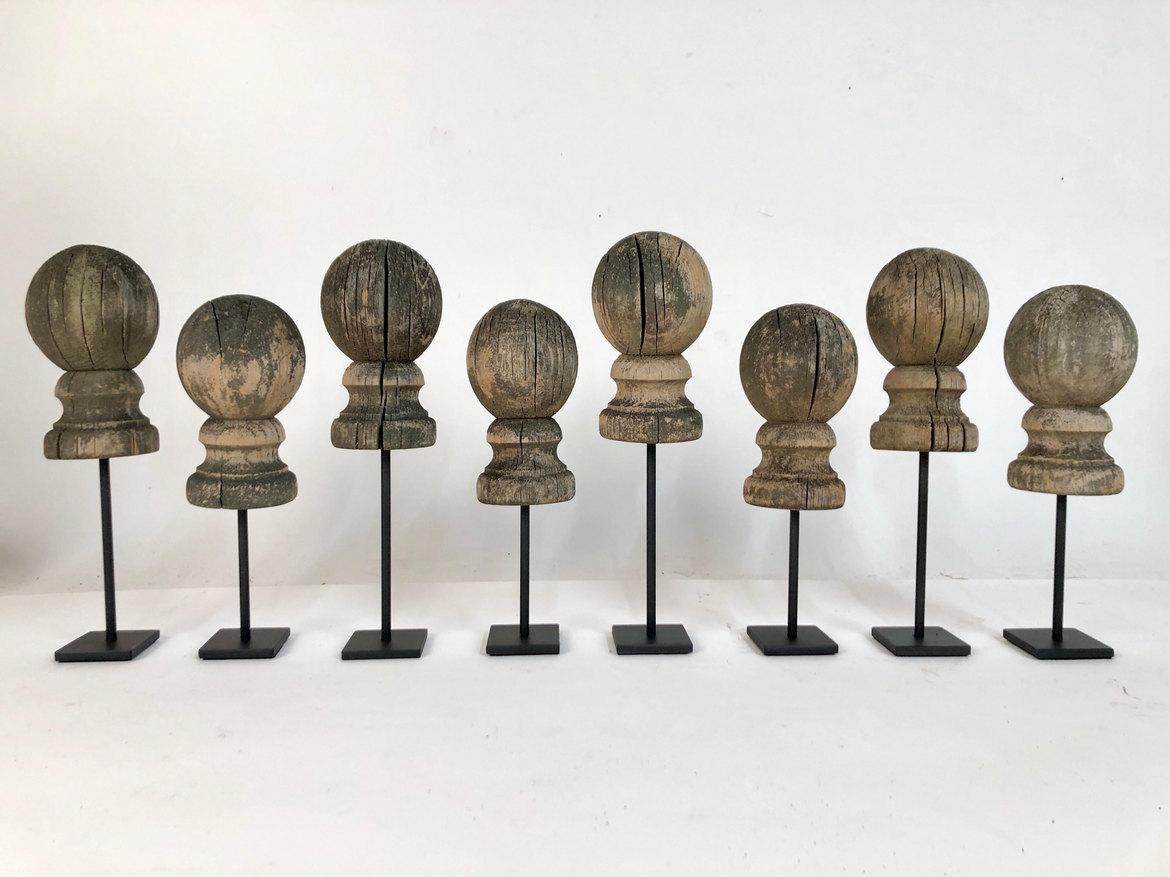 A collection of 8 antique 19th century wooden fence post finials on custom made steel stands. Original beautifully weathered surface. Very sculptural. Finials are 3