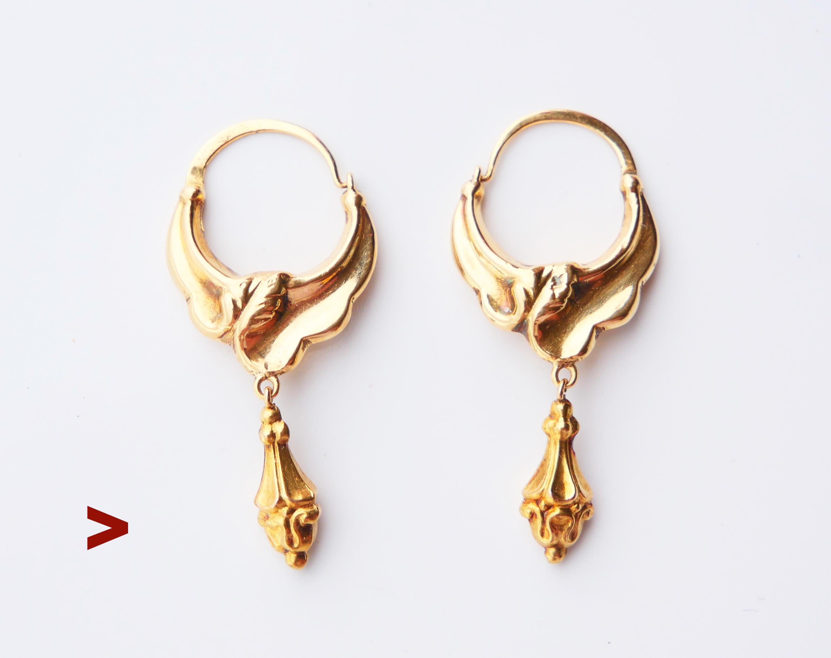 Par de pendientes antiguos con colgantes huecos en forma de borla suspendidos libremente de piezas criollas decoradas con ornamentos florales fundidos por ambos lados.

Sellos suecos en ambos marcados Oro de 18 quilates.

Marcas del fabricante de