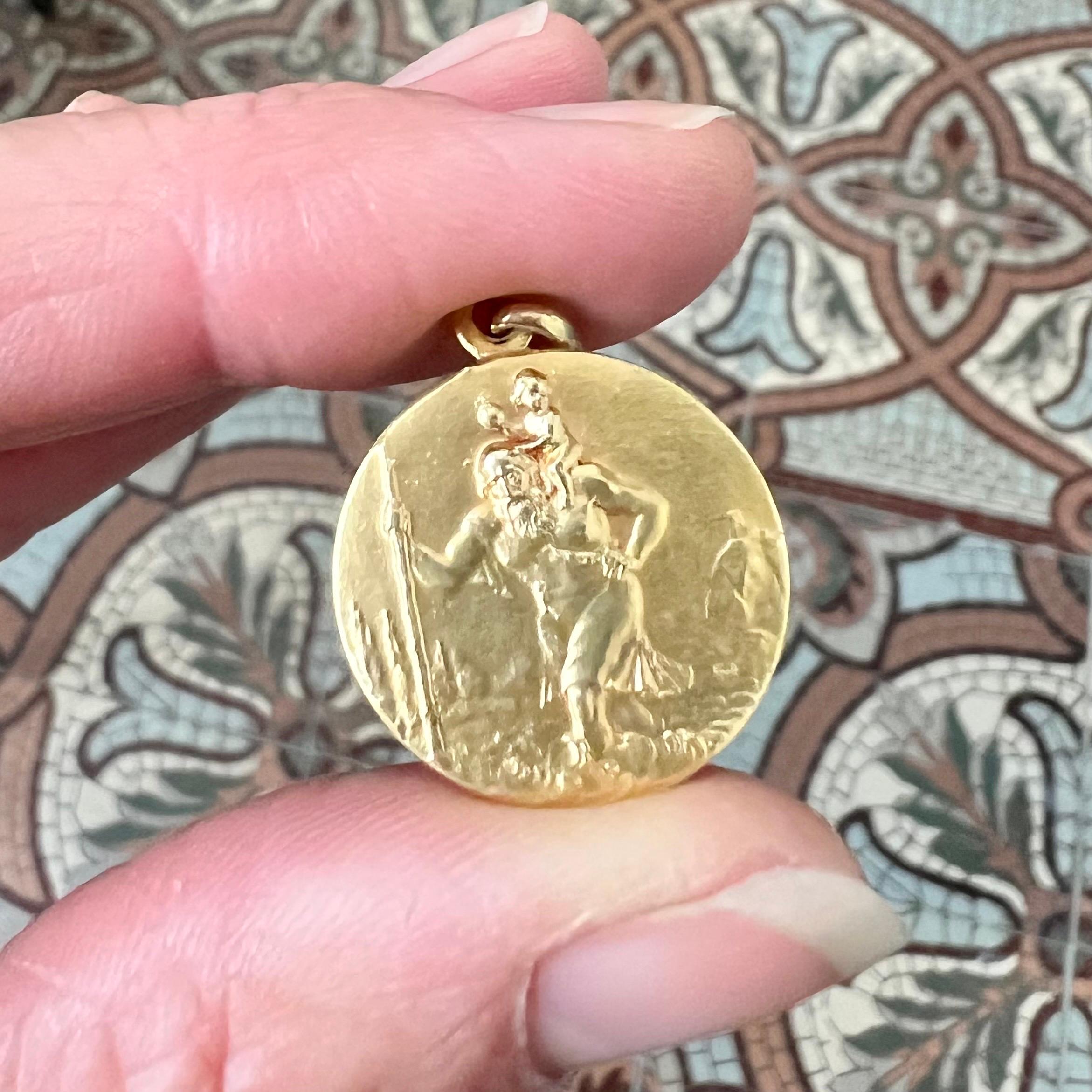 Questo bellissimo ciondolo antico in oro 18 carati è un raffinato esempio di gioielleria devozionale del XIX secolo, con un intricato rilievo di San Christophe, venerato come protettore dei viaggiatori. La parte anteriore del ciondolo raffigura