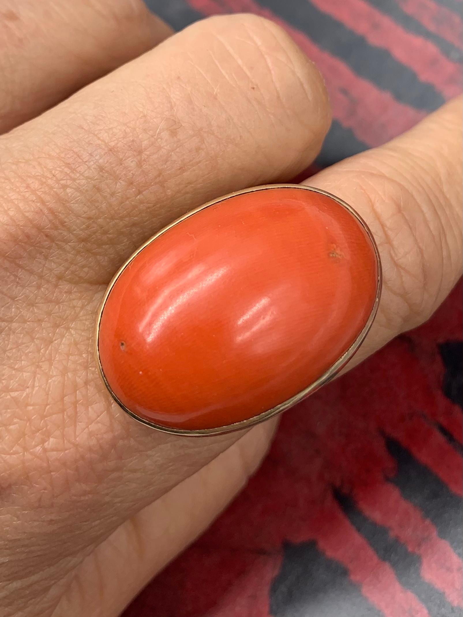 Rare antique very large natural red coral and 14K yellow gold oval ring. 
19th Century
The impressive coral cabochon measuring 30mm by 20mm, one of the largest red coral rings we've seen, approximately 43.5 carats. Well proportioned, of rich even