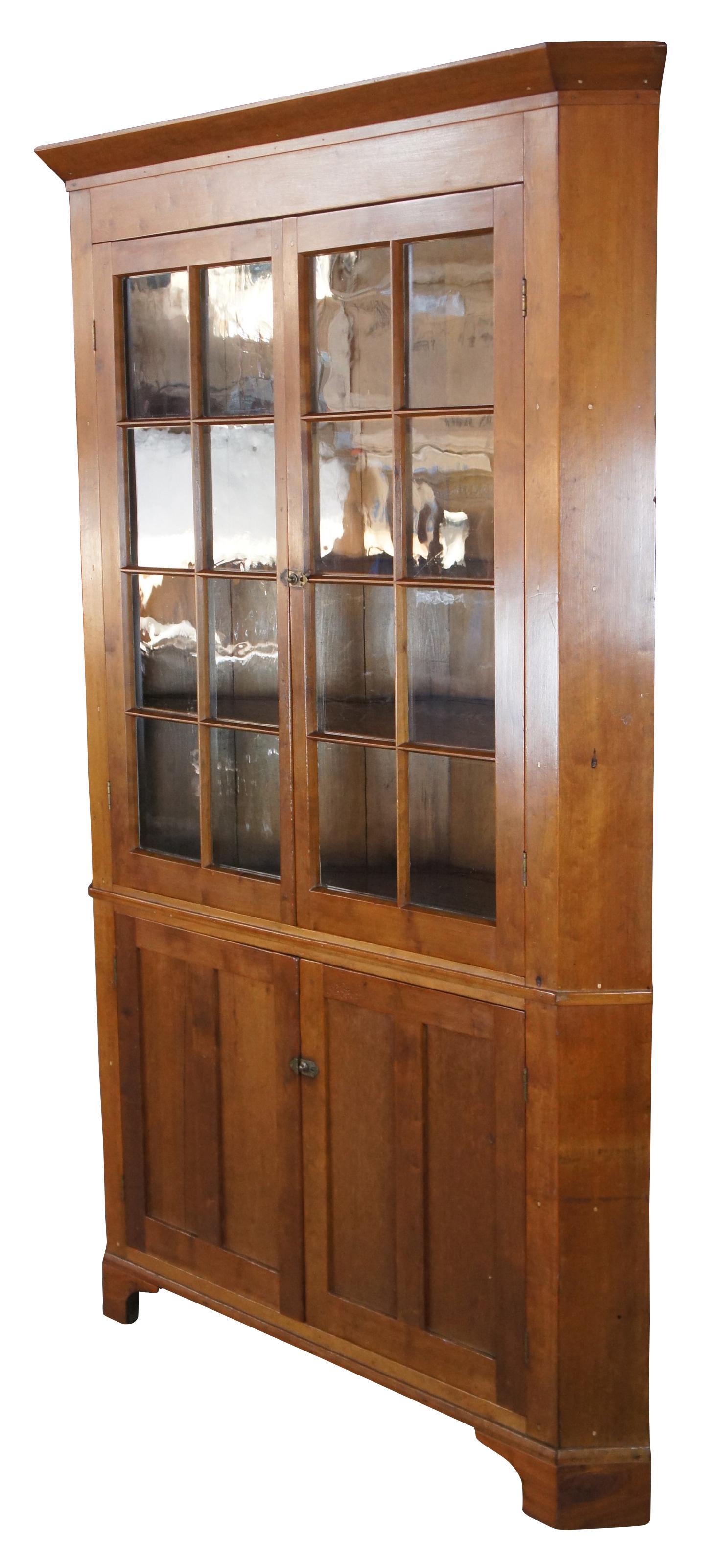 Antique Early American Corner Cabinet. Made from cherry with original glass and oak shelving. Features a 16 pane display portion and four upper shelves with plate grooves. Lower cupboard has one shelf with plate grooves and another without. The