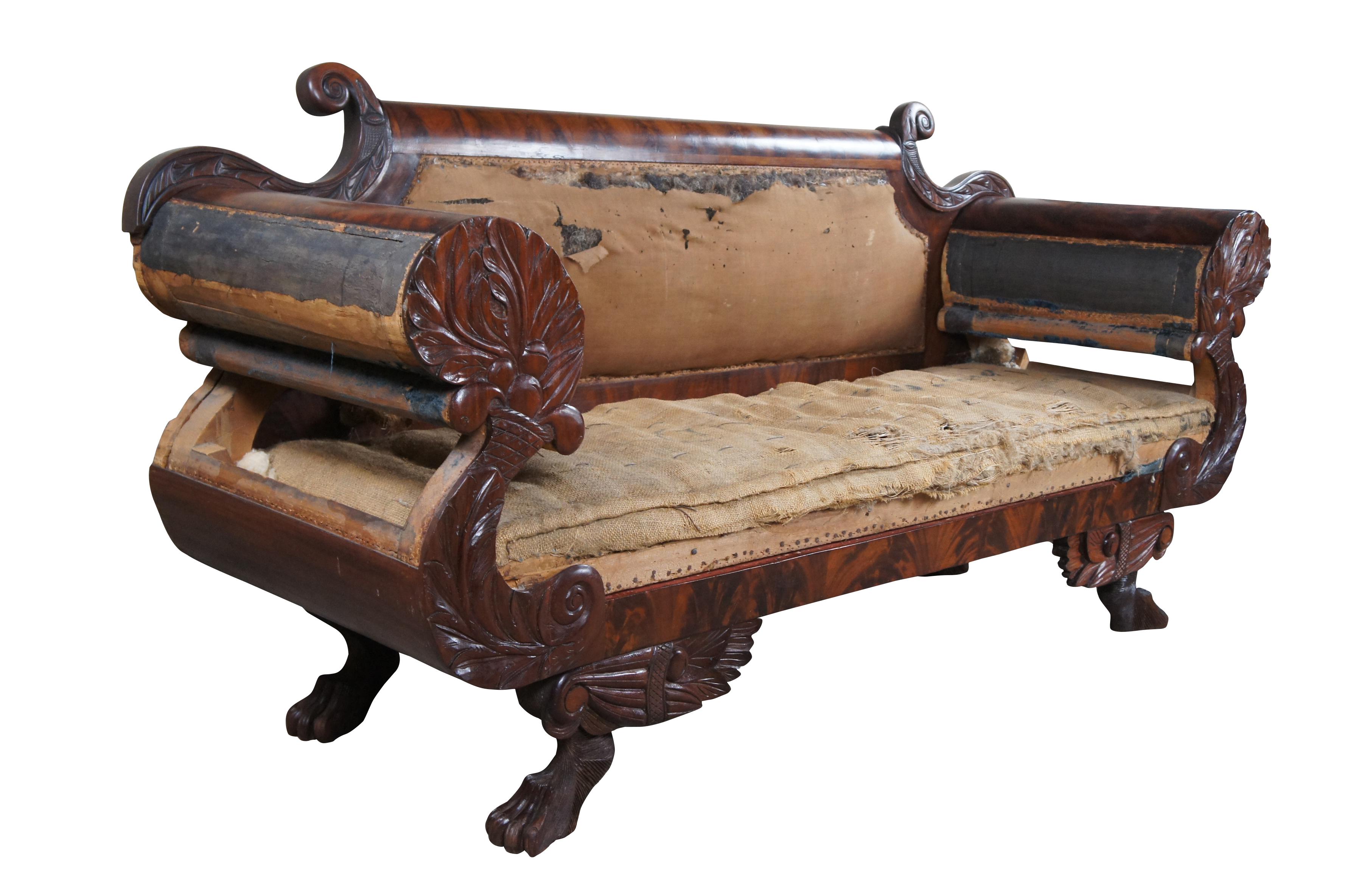 Fine American Empire sofa with striking form and masterful carving, New York; circa 1820s.  Made of flamed mahogany with beveled crest rail between 