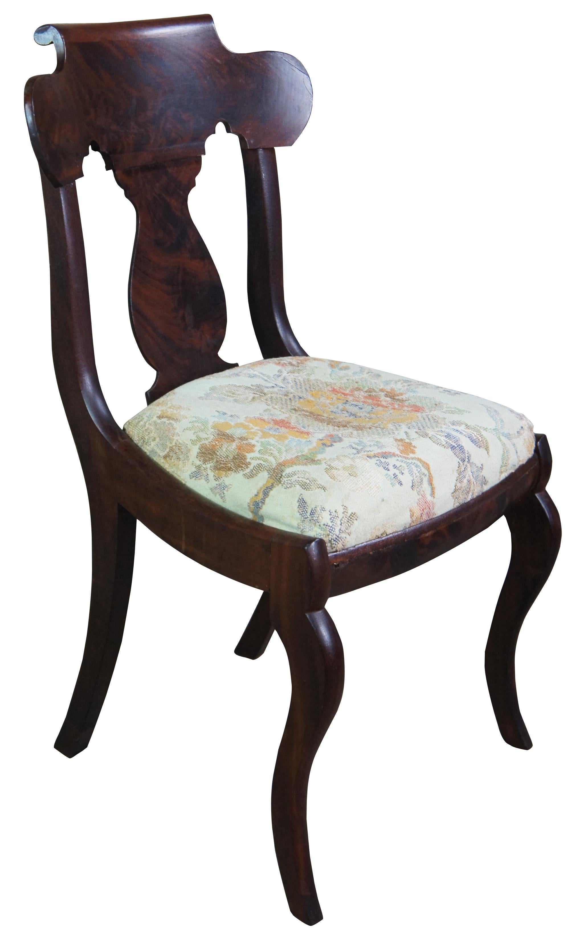 Antique American Empire parlor, vanity or side dining chair. Made of flamed mahogany featuring serpentine form with trophy urn shaped back splat, needlepoint (burlap woven) seat and serpentine legs.
 