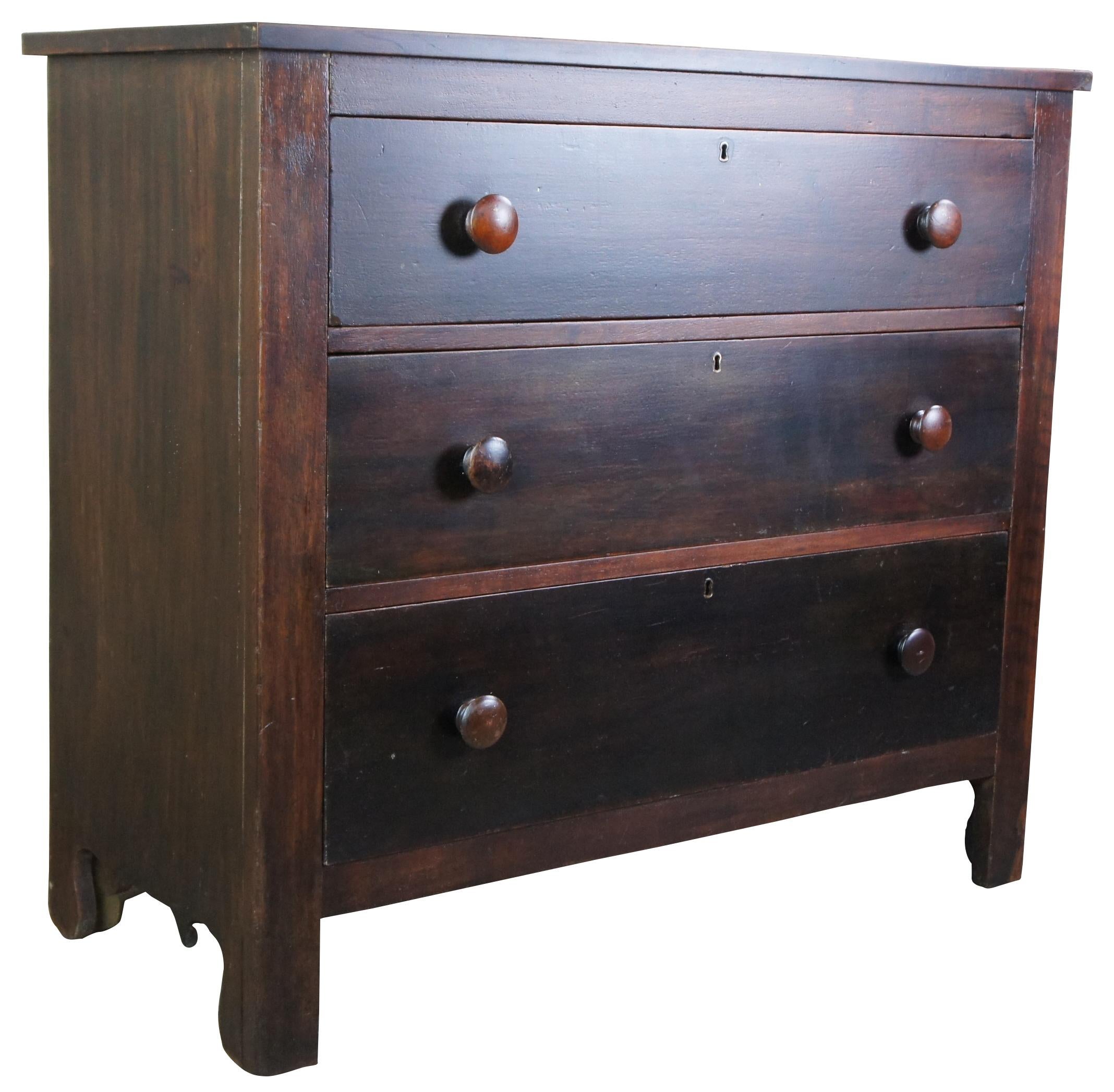 Antique 19th century chest of drawers or dresser. Made of walnut featuring three large hand dovetailed drawers with turned knobs and brass keyholes. Measure: 40