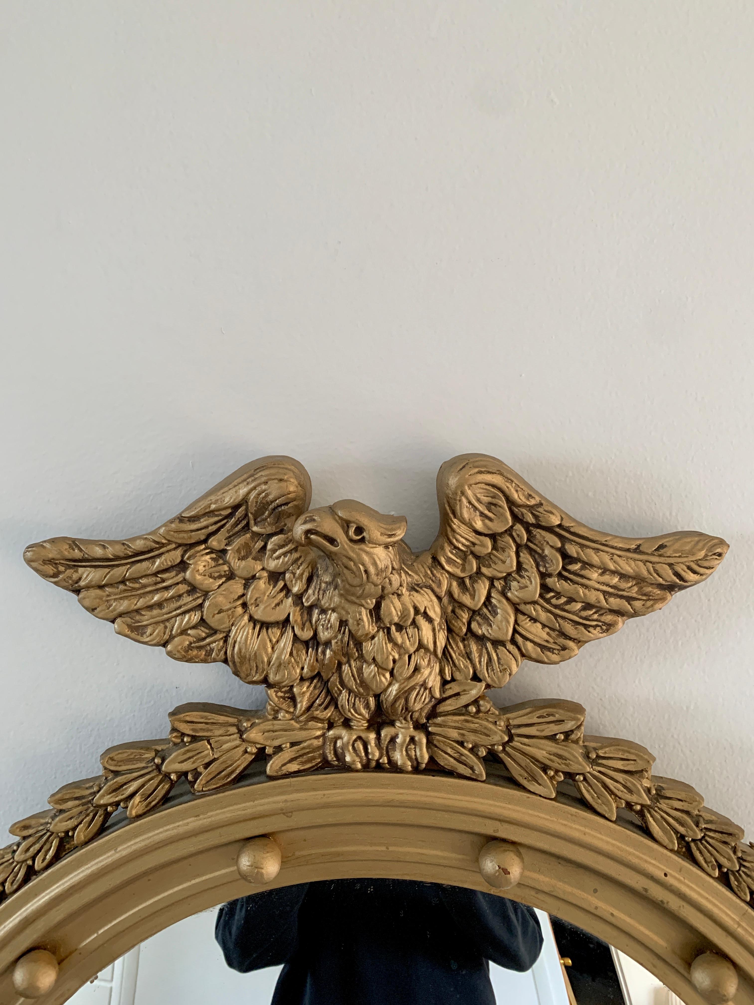 A gorgeous Federal or Regency style convex bullseye wall mirror featuring a carved eagle with open wings standing on olive branches and 13 small spheres representing the original 13 colonies around the inside perimeter.

USA, late 19th