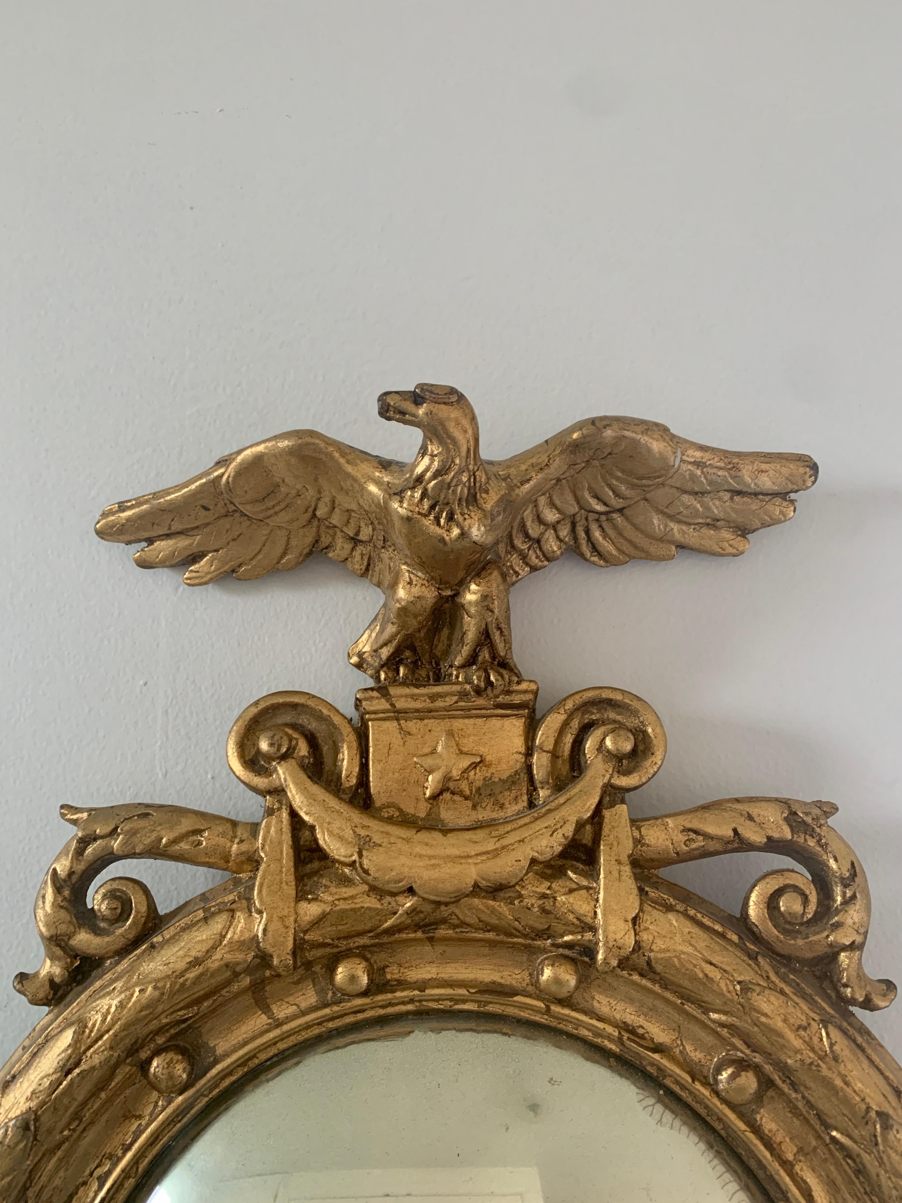 A gorgeous Federal or Regency style convex bullseye wall mirror featuring a carved eagle with open wings and 13 small spheres representing the original 13 colonies around the inside perimeter.

USA, Mid-19th Century

Giltwood frame, with