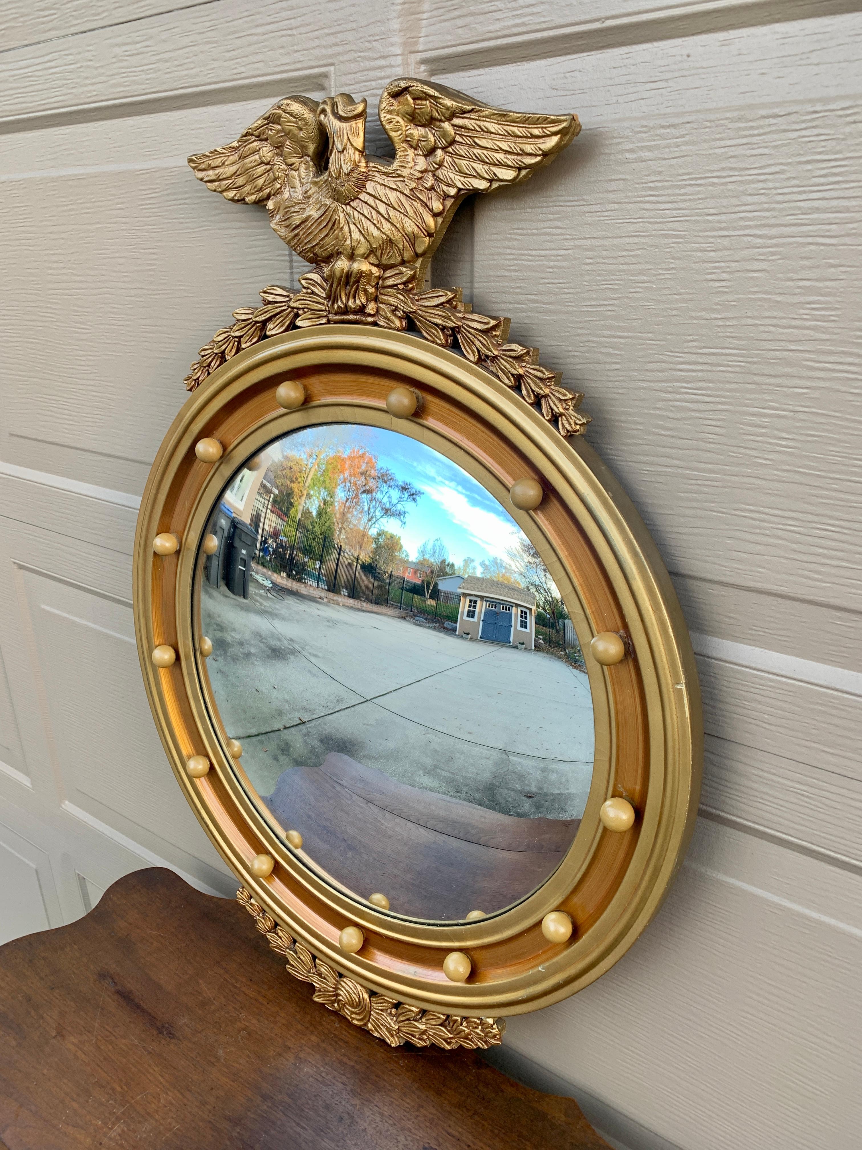 A gorgeous Federal or Regency style convex bullseye wall mirror featuring a carved eagle with open wings standing on olive branches and 13 small spheres representing the original 13 colonies around the inside perimeter.

USA, Late 19th
