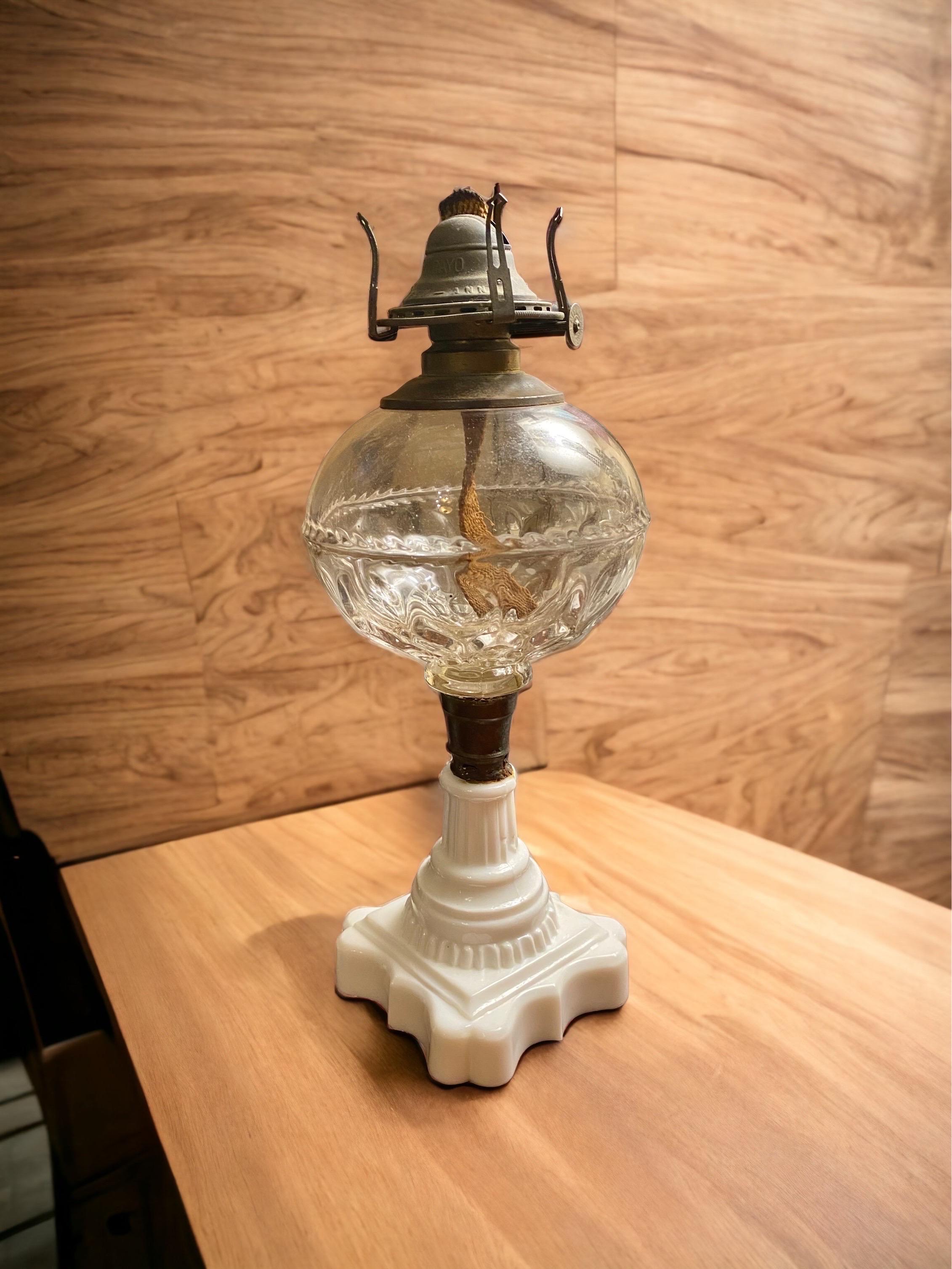 19th Century American whale oil lamp.
Colorless spherical EAPG glass font, high-lead opalescent white Milk Glass scalloped square base with tapered stem, brass connector,
No. 1 fine-line brass collar.
Fitted with a period Queen Anne burner and