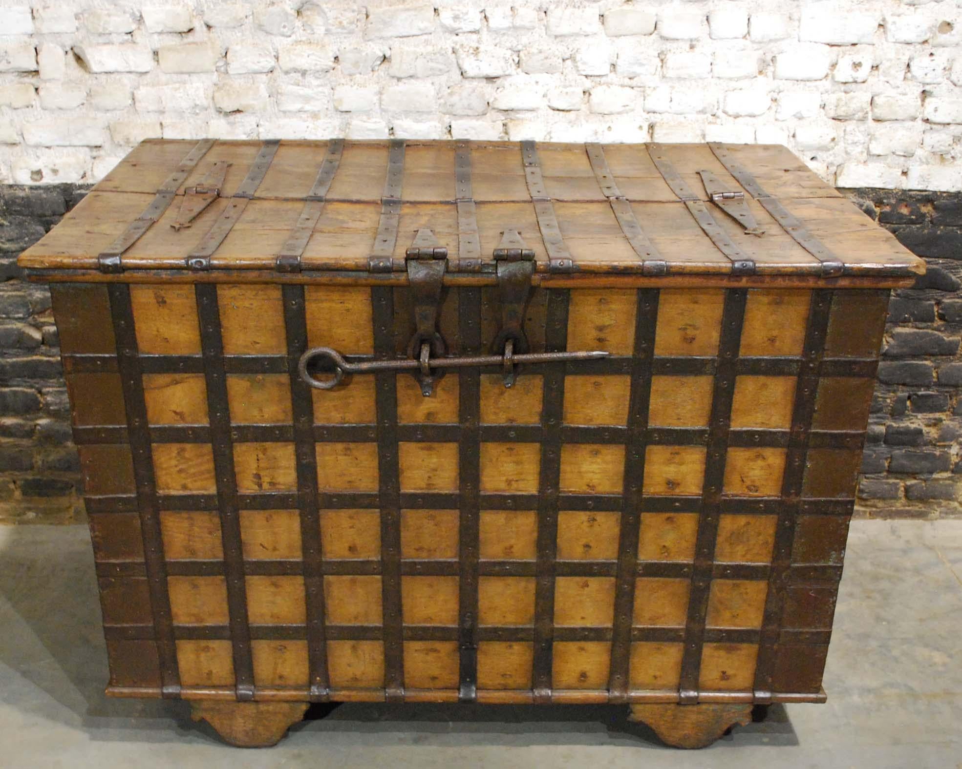 A mid-19th century, Anglo-Indian Trunk with original ribbed iron fittings. 
The trunk or chest is made in solid teak wood and richly decorated with hammered and forged iron strappings. It has a hinged top hatch that can be locked by the use of a