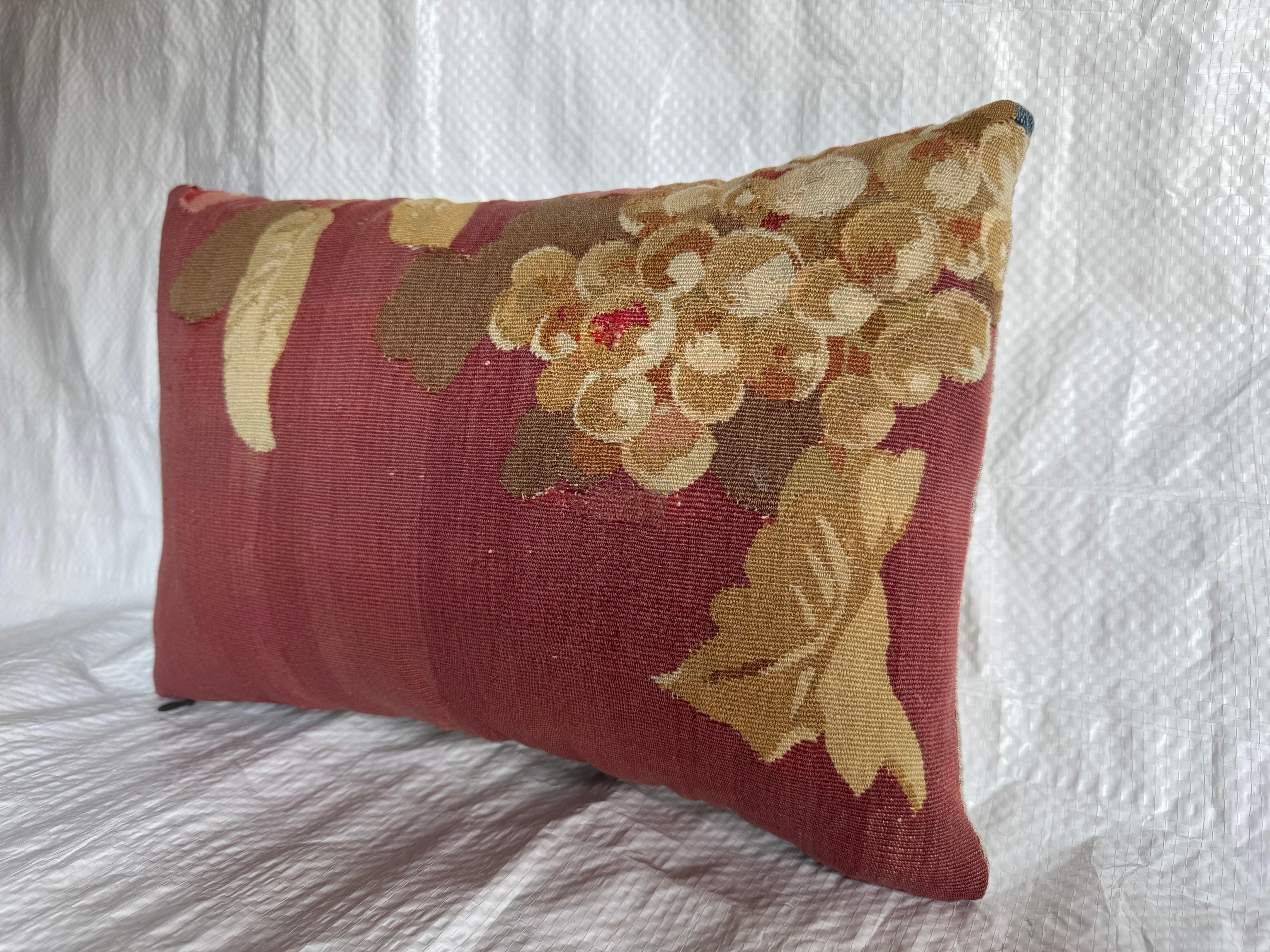 Coussin en tapisserie d'Aubusson, France, vers 1850. Cette pièce présente une grappe de raisin richement tissée avec du feuillage dans des tons doux d'or, de beige et de vert sur un fond bordeaux chaud. Le design capture l'élégance et la qualité