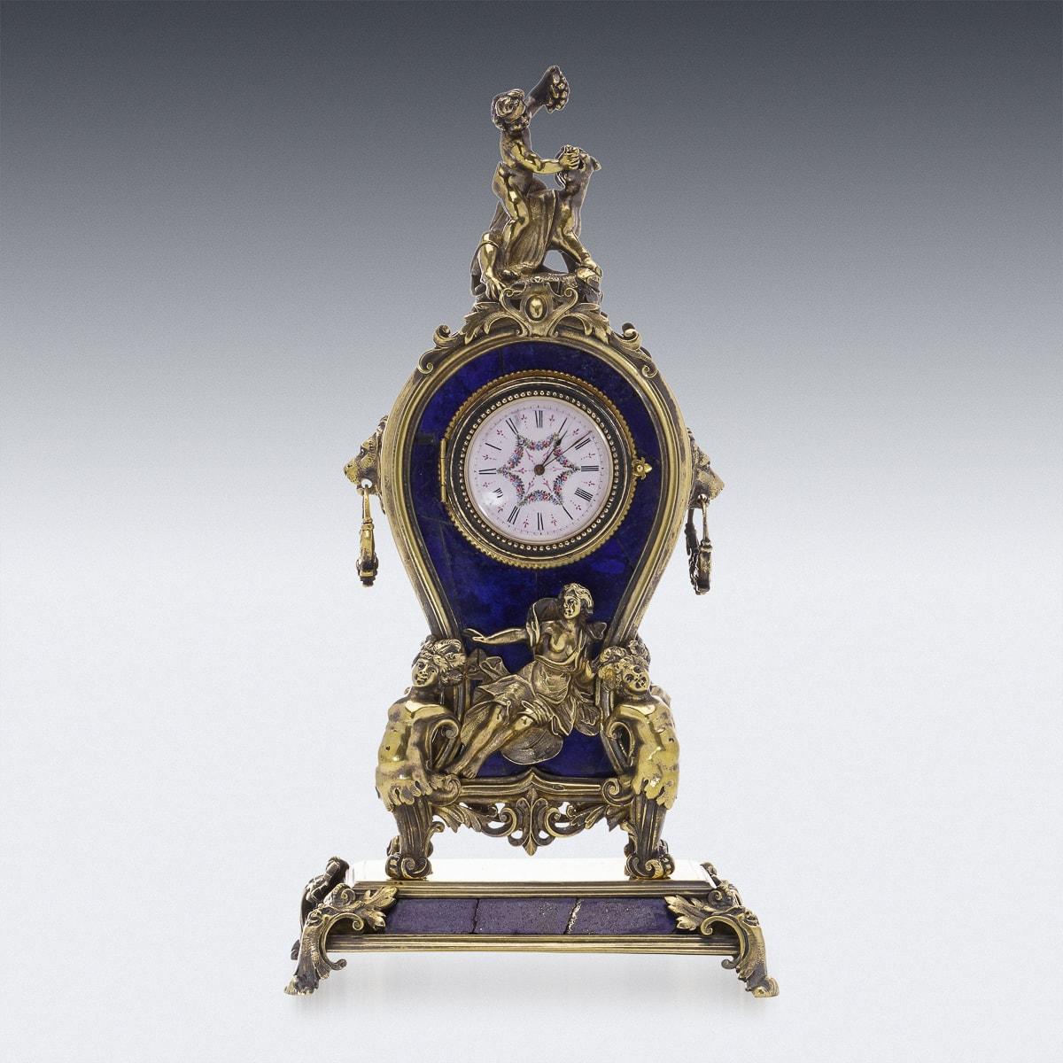 Antique late-19th Century Austrian exceptional solid silver gilt & lapis lazuli miniature clock, At the top, a cherub feeds grapes to a panther, while a pair of lion masks adorn the sides. In the clock's center, four nymphs hold the lapis body, with