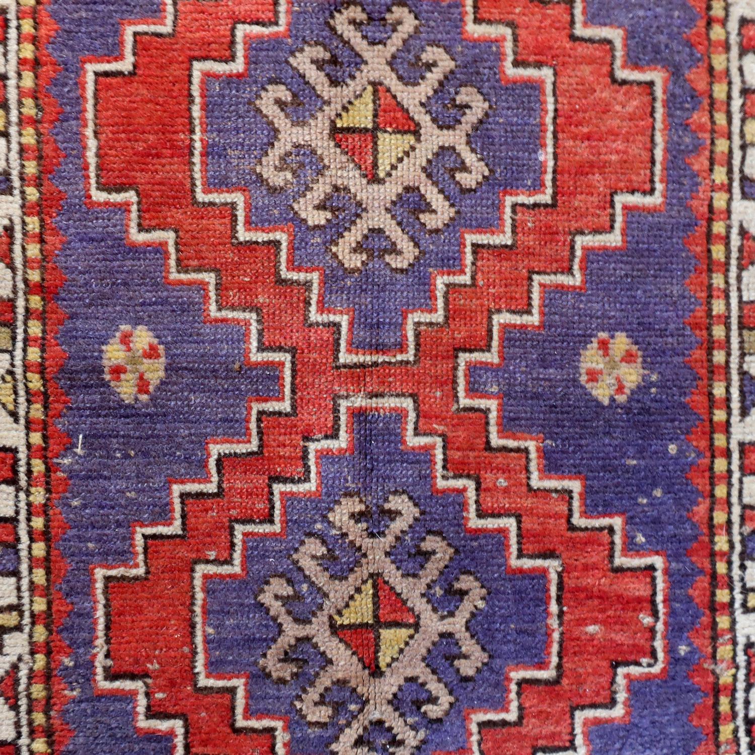 A beautiful handwoven red, blue, tan, and off-white Baluch rug.  Sometimes spelled as 
