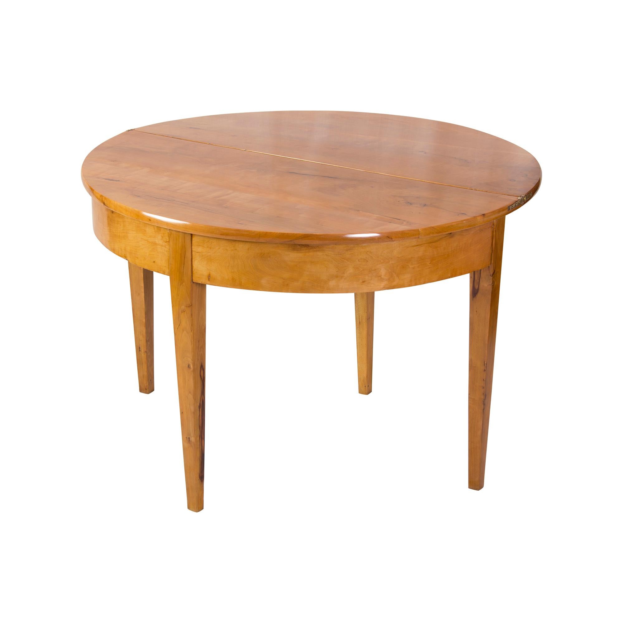 Schöne Demi Lune Tisch kann gegen die Wand als Konsole halbkreisförmig platziert werden. Oder zusammengeklappt in der Mitte des Raumes als runder Tisch. Der Tisch ist aus Pflaumenholz gefertigt. Das Holz hat eine schöne, kirschähnliche Farbe. Die