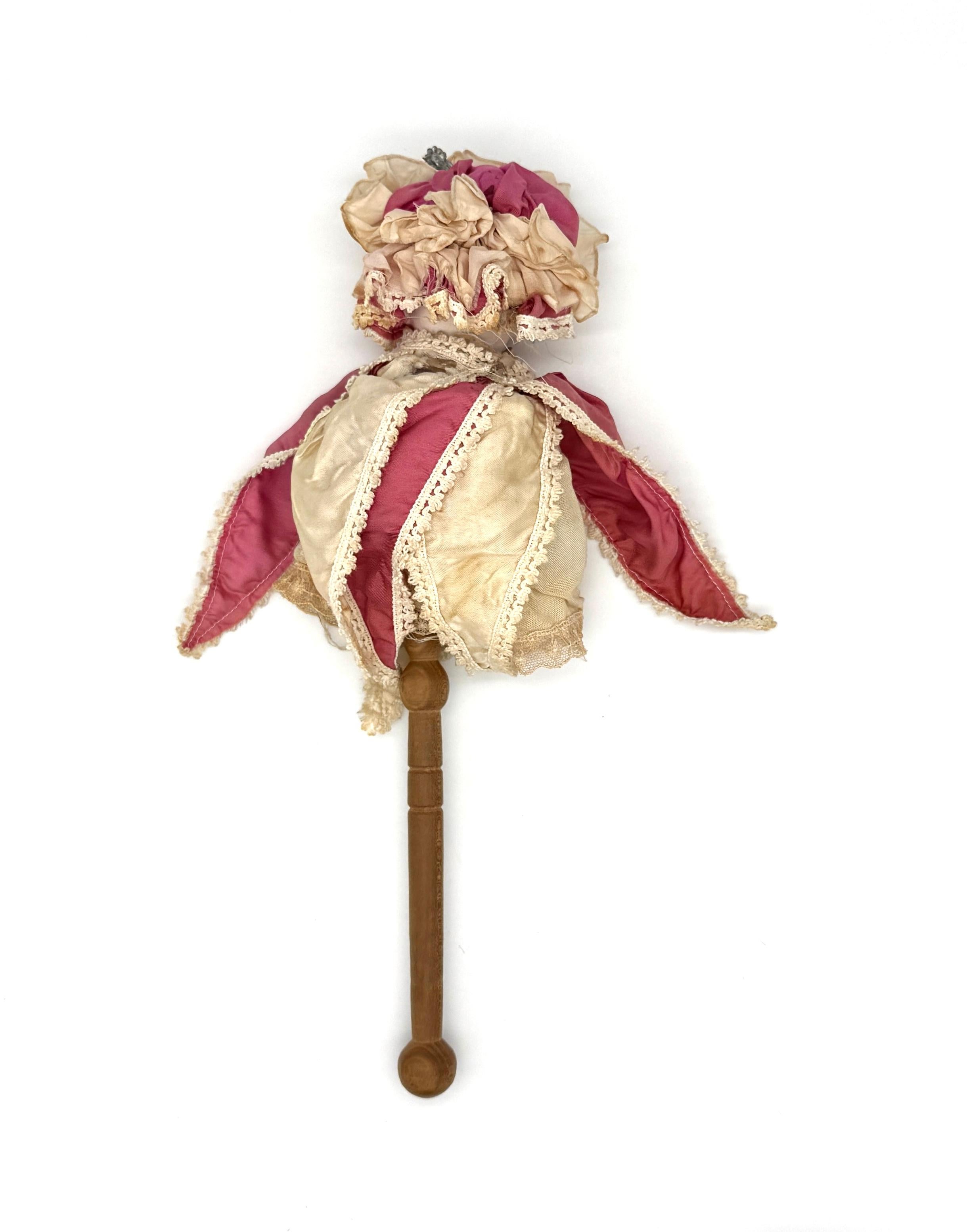 Questa rara bambola in porcellana di bisquit, una cosiddetta Marotte, è stata creata in porcellana di bisquit nel 1880 circa. La bambola è vestita da giullare, il costume bicolore e la cuffietta sono in buone condizioni. La bambola è vestita con una