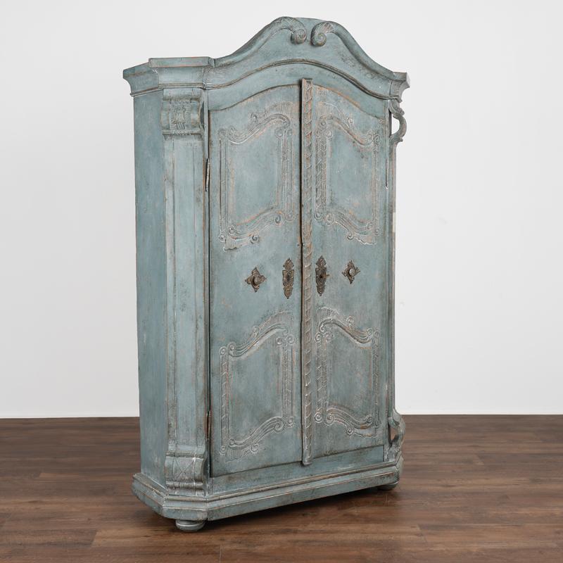 The remarkable paint and carved details on this lovely French armoire add allure to the piece. Please review the close up details to appreciate the professionally applied newer blue painted finish. The layers of blue and white/cream is enchanting,