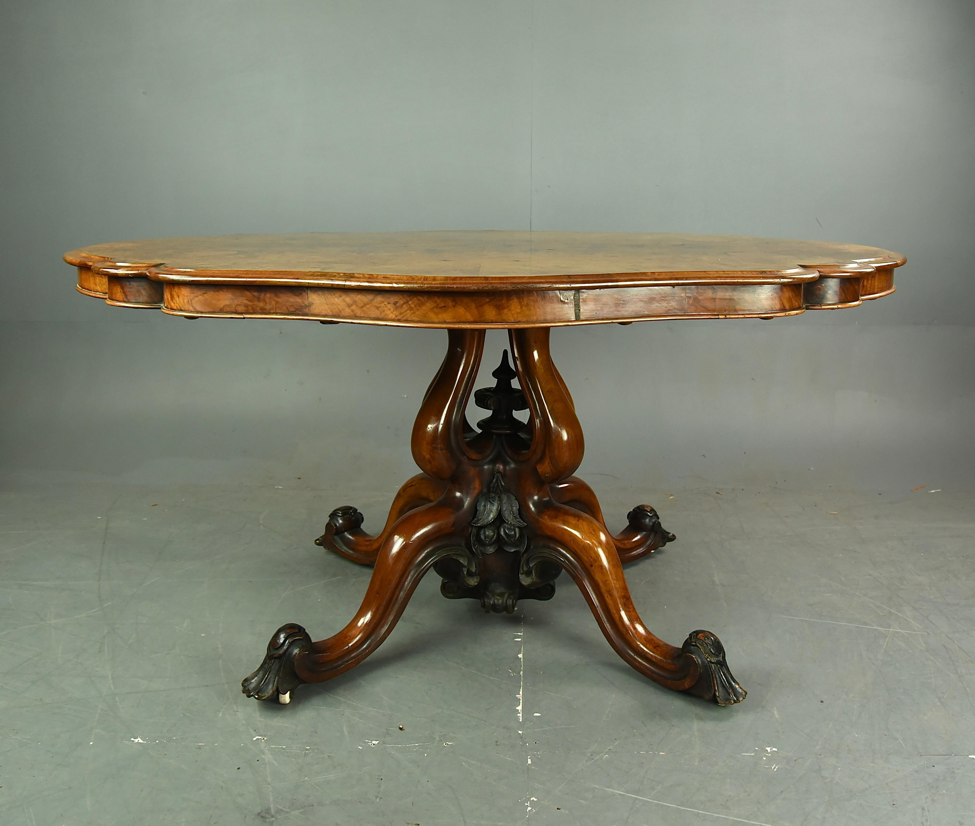 A stunning and top quality large Victorian burr walnut tilt top centre or dining table. The shaped oval top having wonderful book matched burr walnut veneers with a thumb moulded edge. The superb base supported on a quatrefoil pierced column with