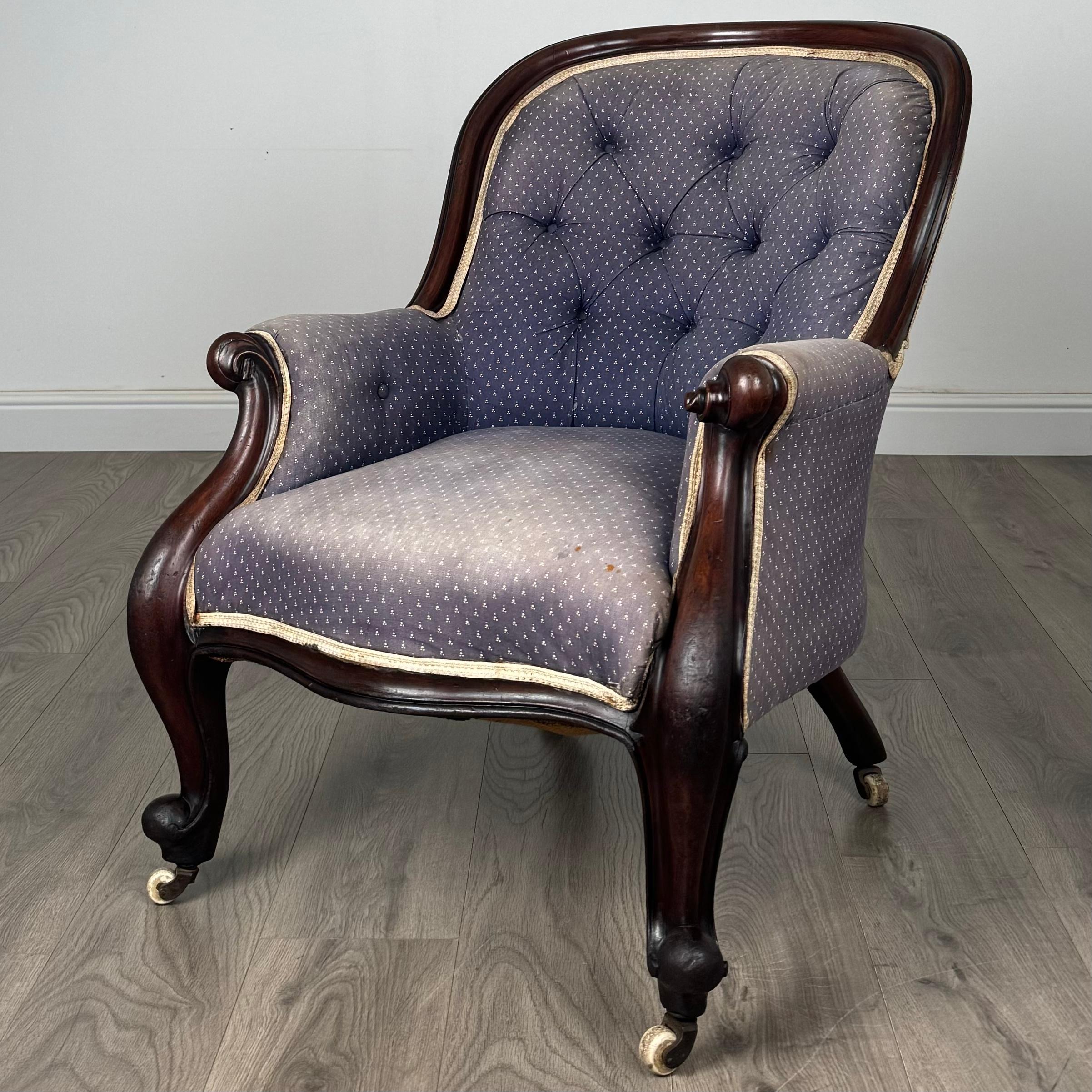 Ce fauteuil ancien à dossier boutonné du XIXe siècle est un exemple étonnant de design et d'artisanat classiques. Fabriquée en acajou de haute qualité, la chaise présente des accoudoirs élégamment sculptés et des pieds en cabriole qui sont complétés