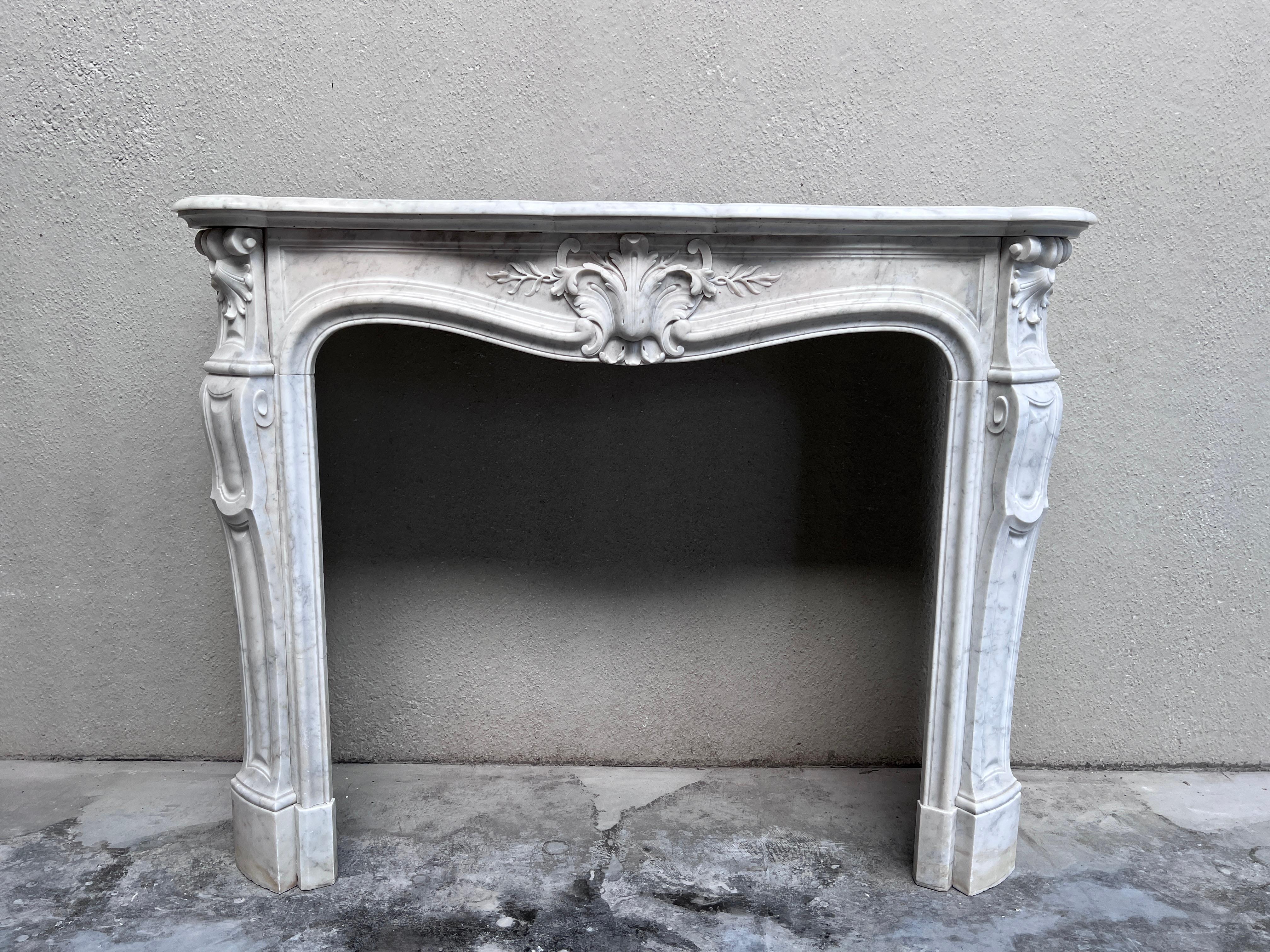 Antique 19th Century Louis XVI fireplace in Carrara marble with elegant ornaments.