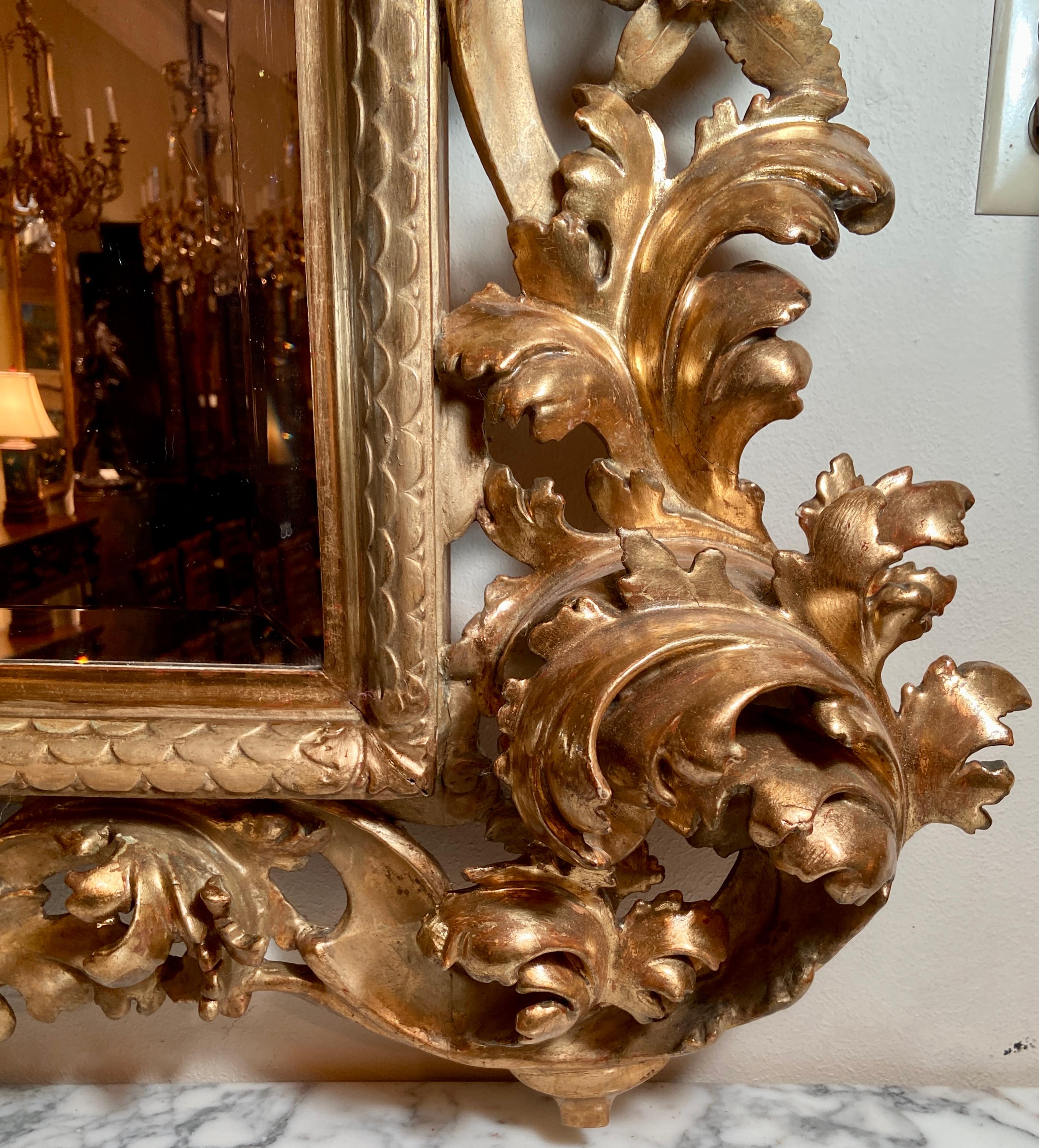 Antique 19th century extraordinary carved wood with gold leaf beveled mirror, circa 1880-1890.