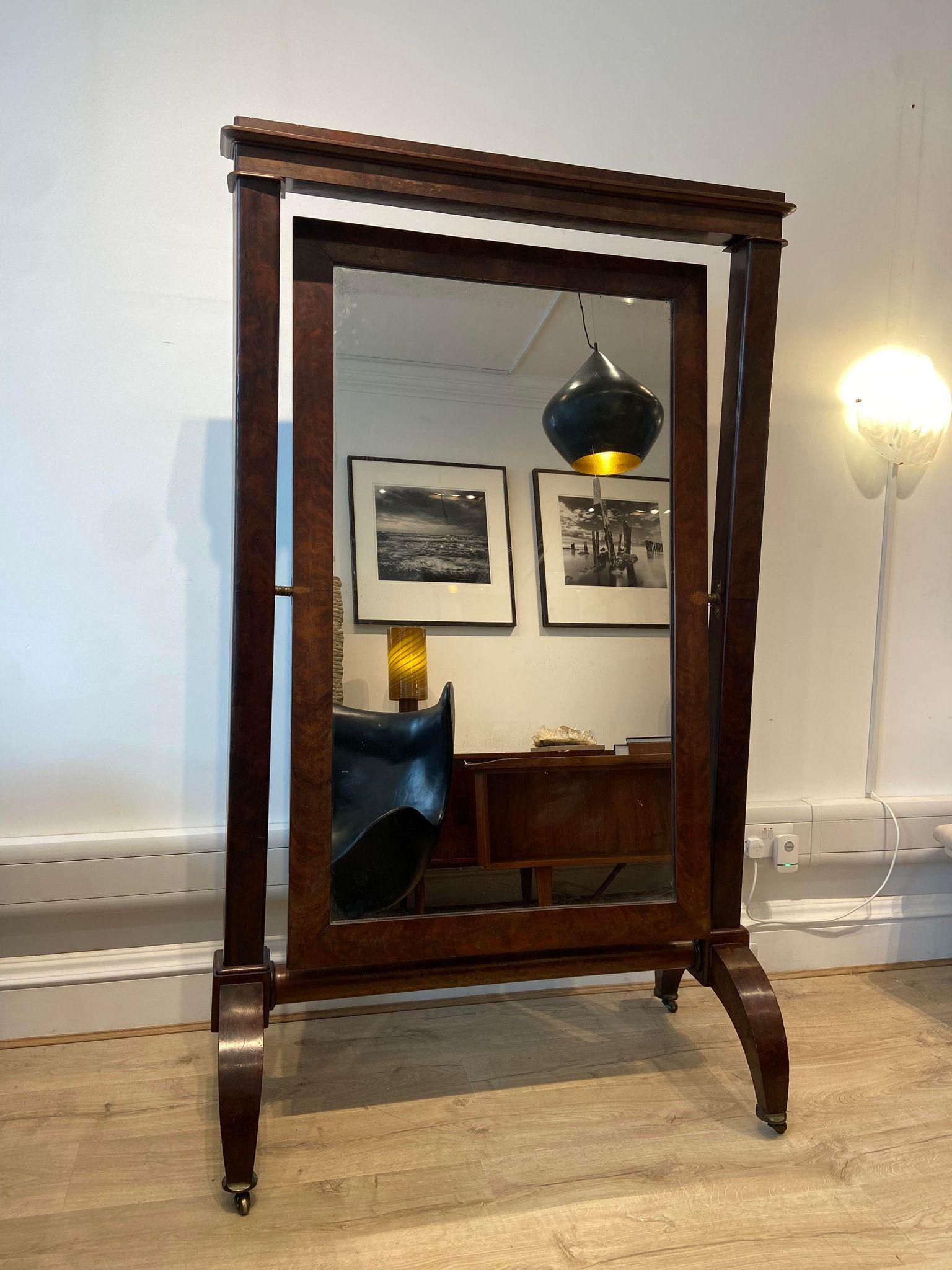 An antique floor standing Cheval mirror set on brass castors. 

Dimensions: 
Height: 183 cm
Width: 106.5 cm
Depth: 53 cm 
