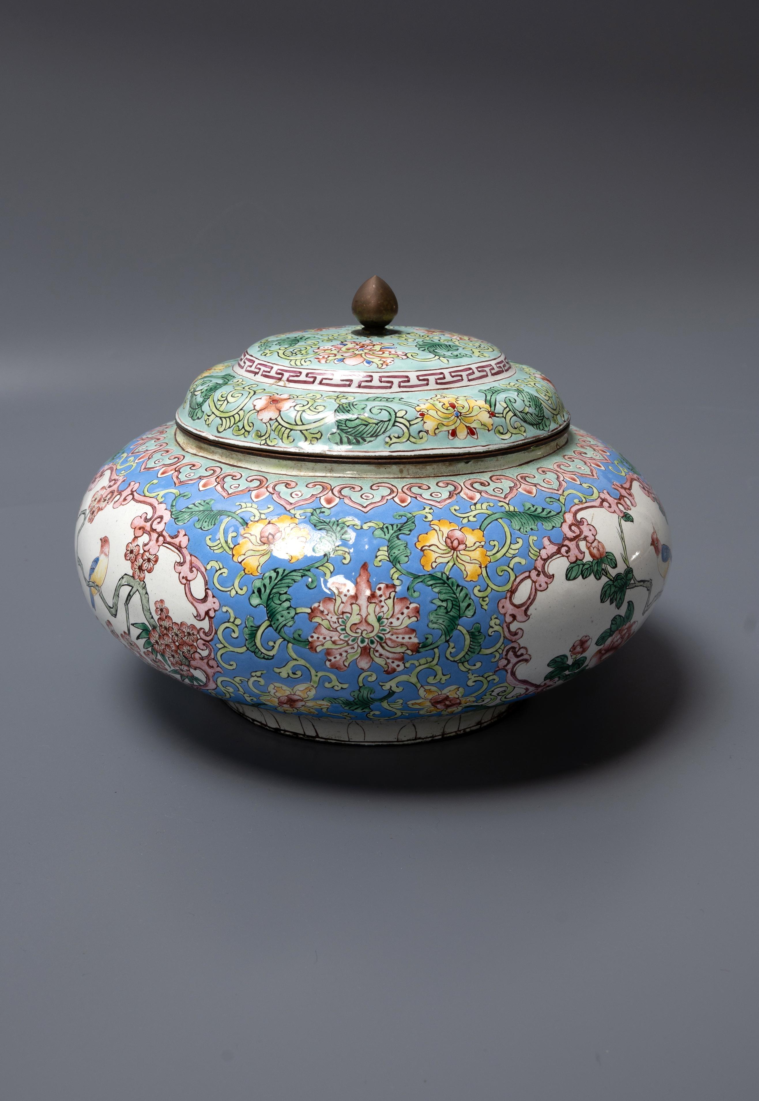 A CHINESE CANTON ENAMEL POT AND COVER
19th Century, in the Qianlong manner, of compressed form and painted with panels enclosing birds perched amidst flowering peonies, 18cm diameter.
Wax seal to the inside of the lid.
Enamel in very good condition